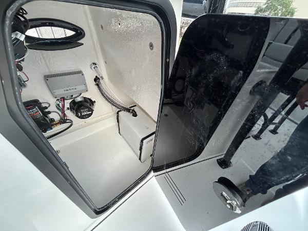 2024 Sea Pro 250 DLX boat interior with open storage compartment and visible wiring.
