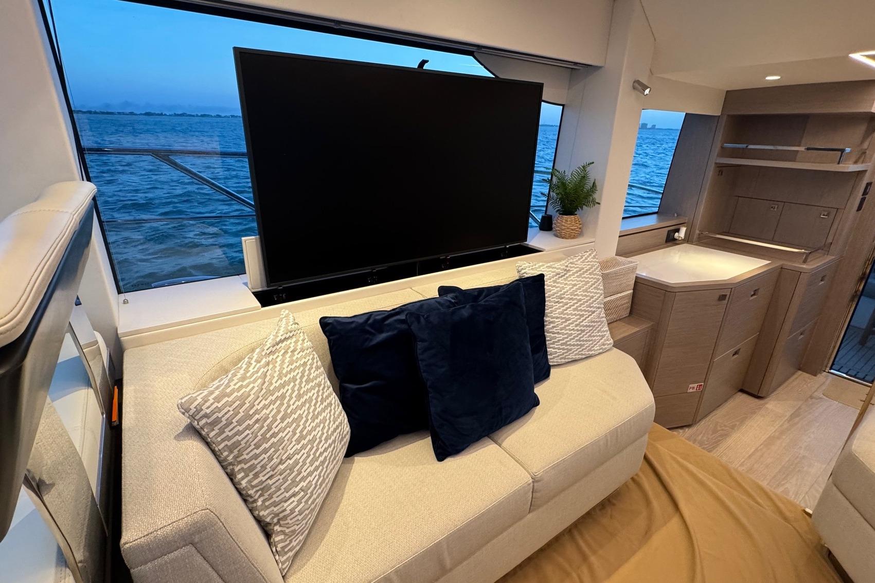 Luxurious interior of 2024 Sunseeker Manhattan 55 yacht with plush seating and ocean view.