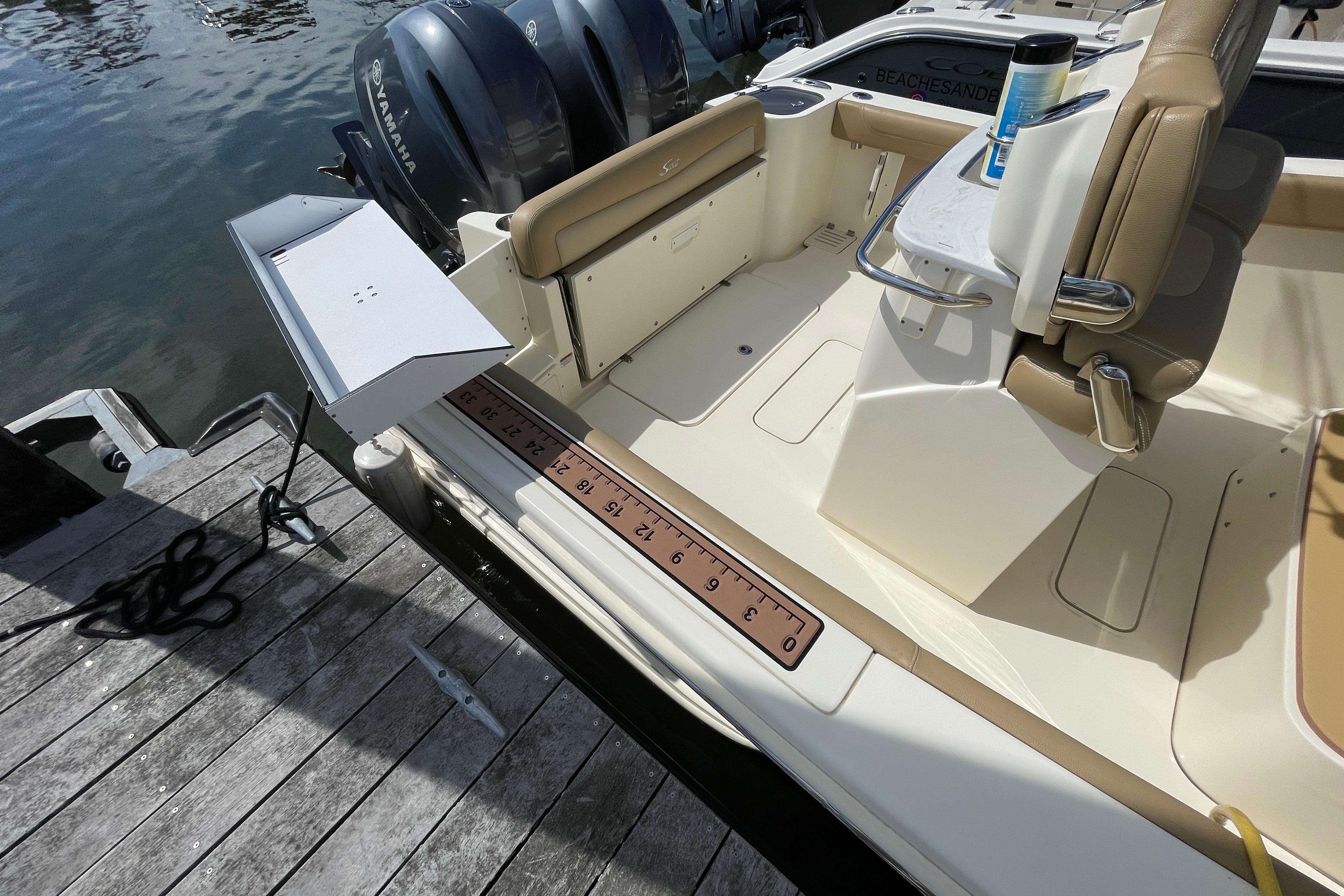 2020 Scout 255 LXF boat interior with Yamaha engines, docked by wooden pier.