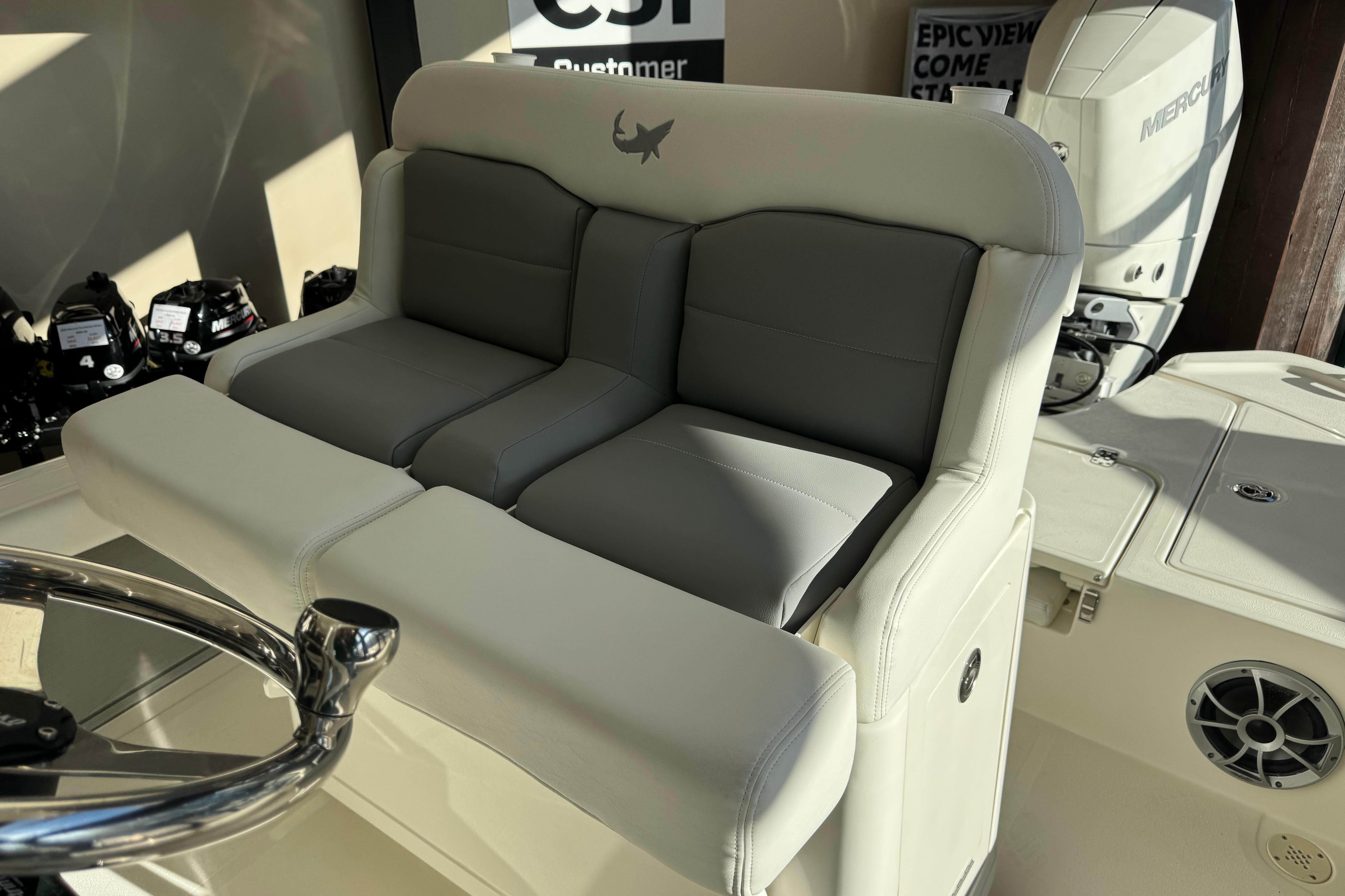 2026 Mako 24 APEX boat interior with cushioned seating and steering wheel.