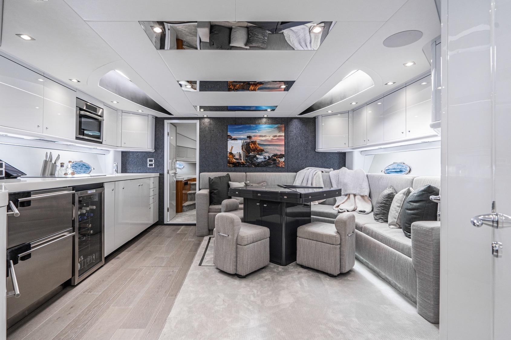 Luxurious interior of 2021 Sunseeker Predator 68 yacht with modern kitchen and elegant seating area.