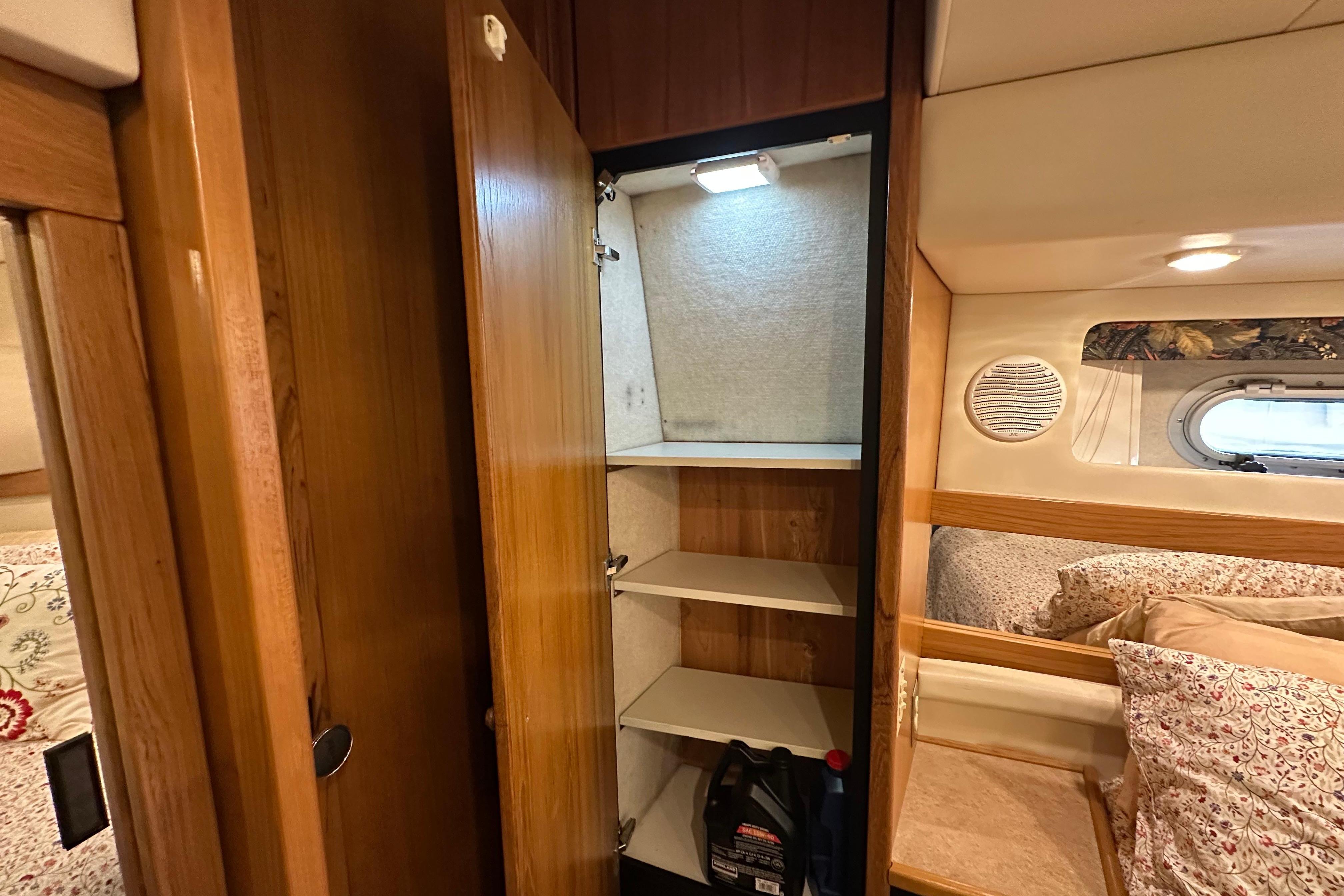 Interior of 2000 Bayliner 4087 Aft Cabin Motoryacht with open wooden cabinet and cozy bedding.