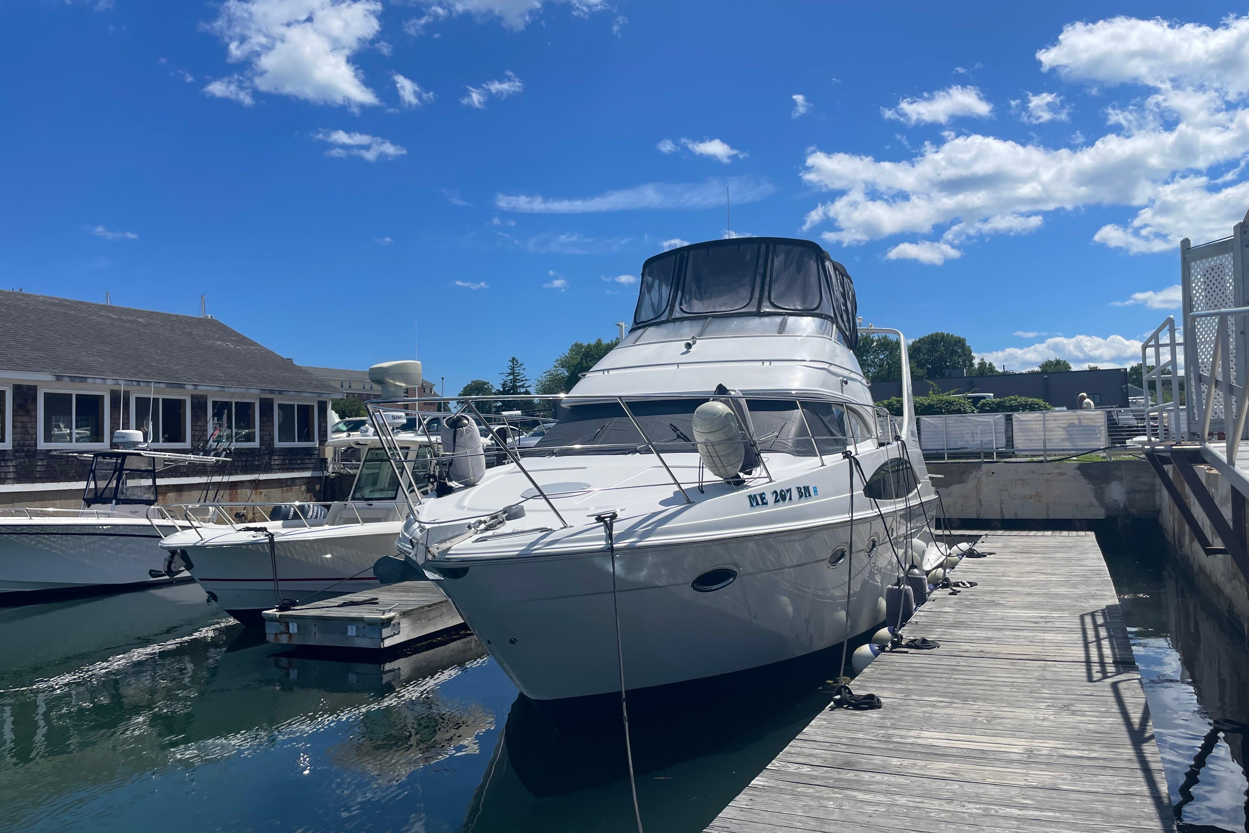 2002 Carver 410 Sport Sedan docked at marina under clear blue sky.