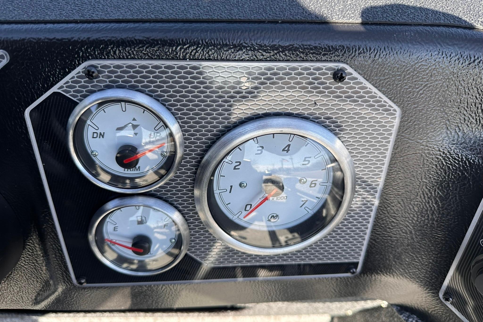 Dashboard gauges of 2026 Lund 1875 Impact XS SS boat, featuring trim and fuel indicators.