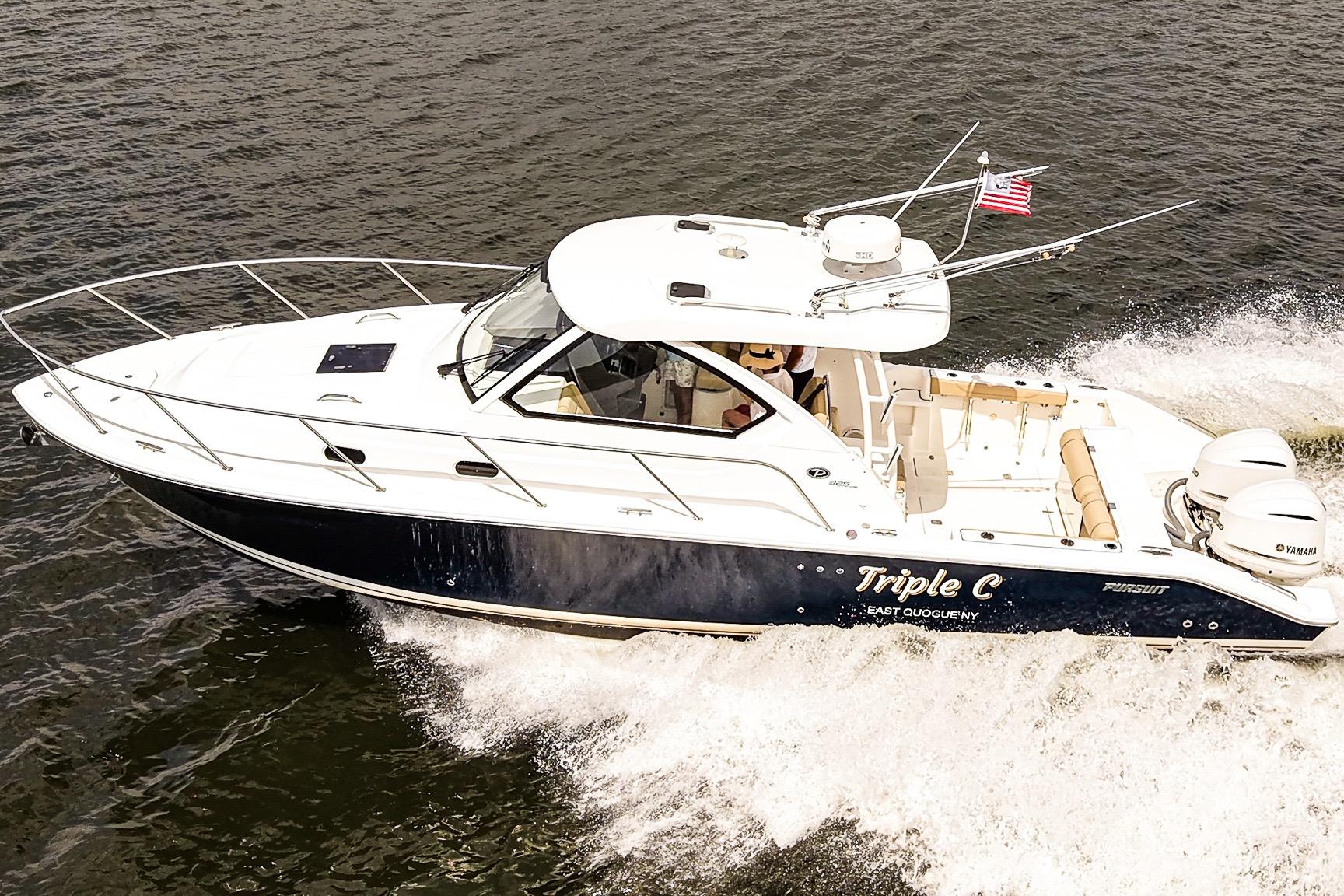 2020 Pursuit OS 325 Offshore boat cruising on water with American flag.