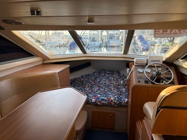 Interior of a 2008 Bayliner Discovery yacht with helm and sleeping area.