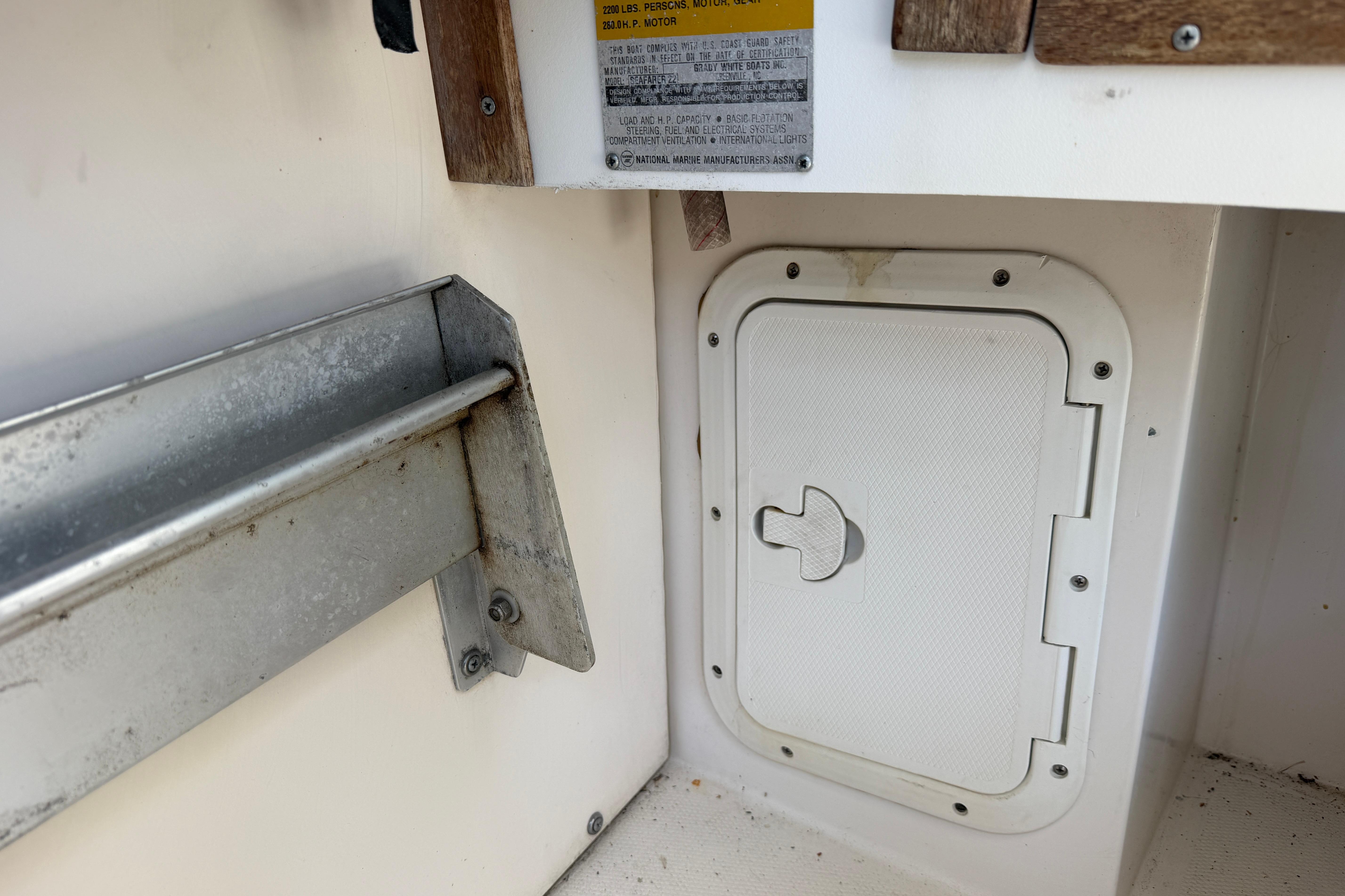 1987 Grady-White Seafarer 226 boat interior, featuring a storage compartment and metal bracket.