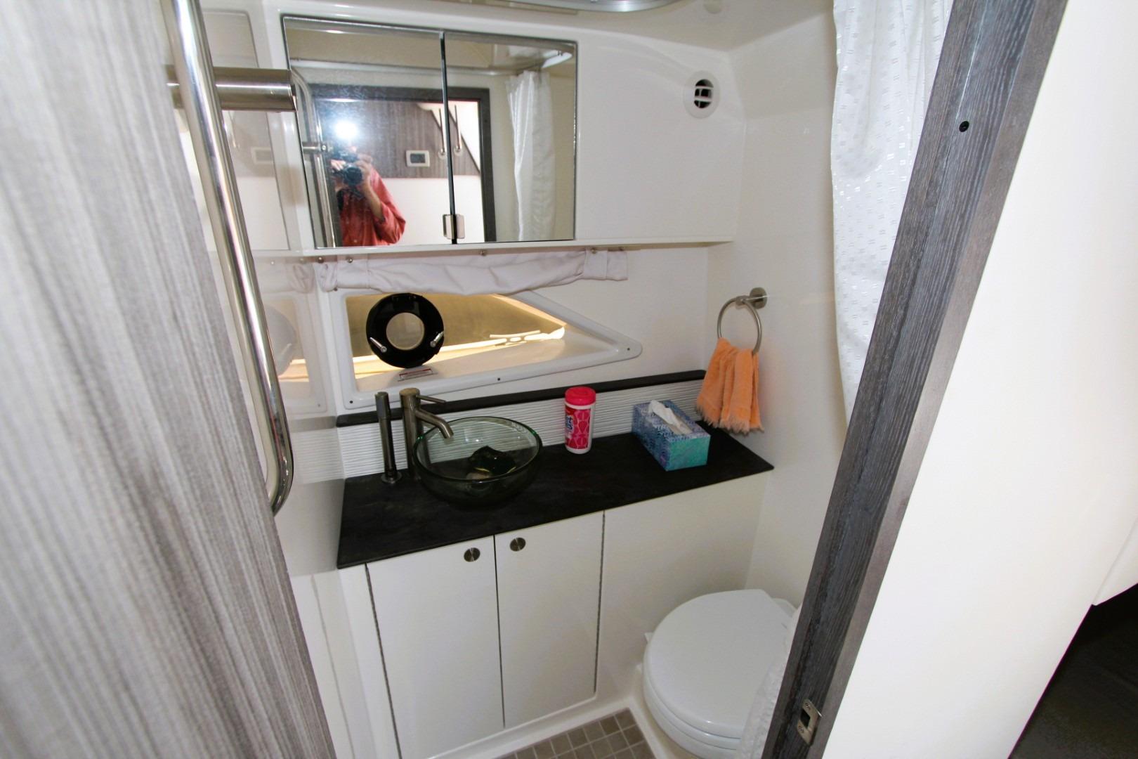 2021 Sea Ray Sundancer 320 Outboard bathroom with modern sink, mirror, and storage cabinets.