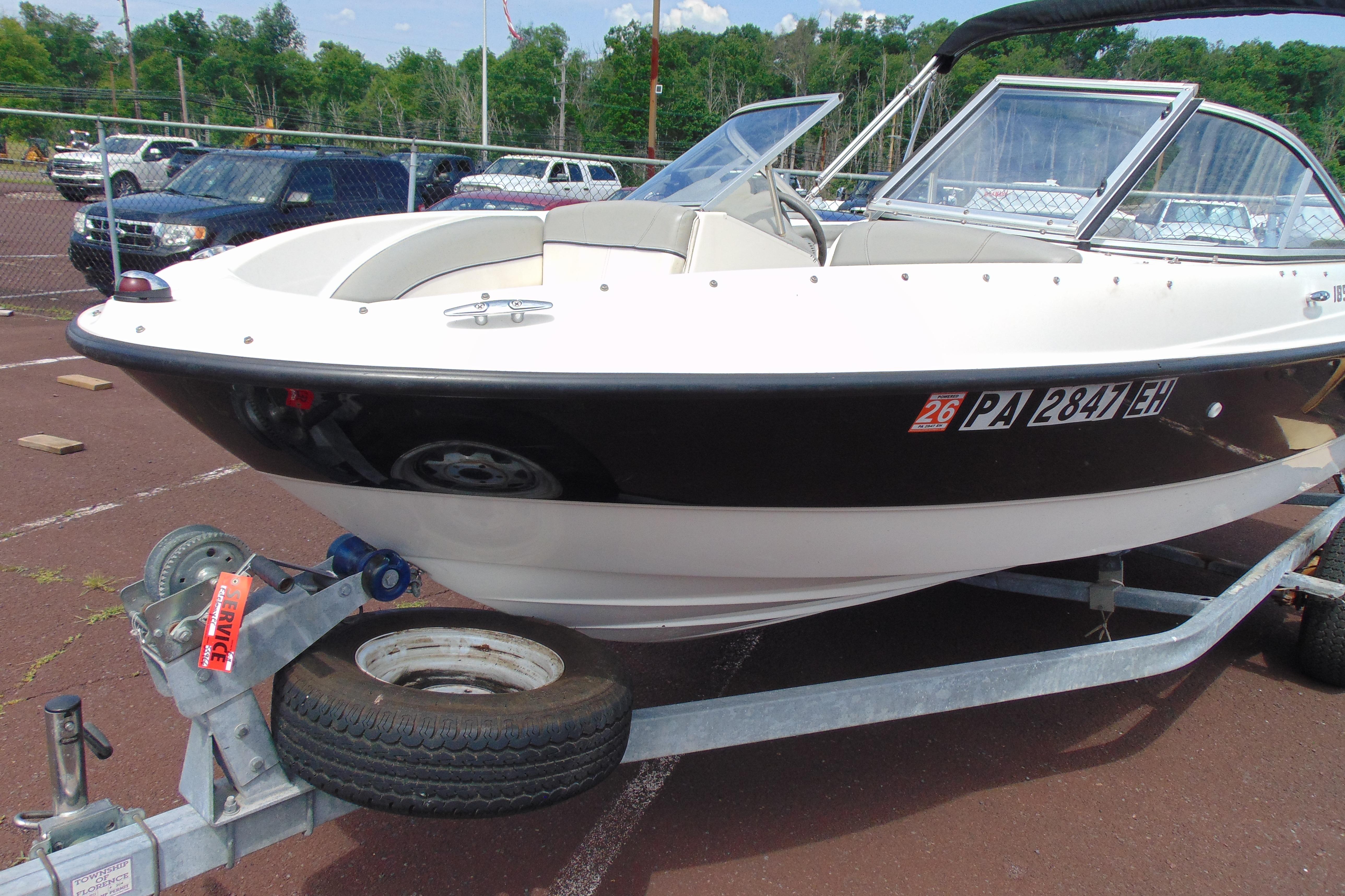 2012 Bayliner 185 Bowrider on trailer in parking lot, side view.