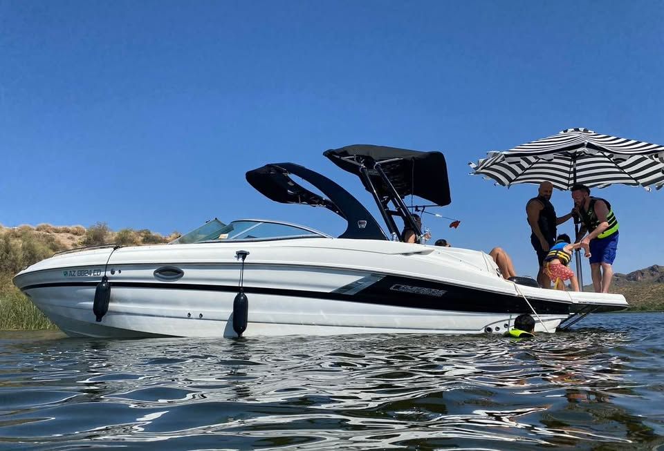 2016 Cruisers Sport Series 29SS boat on water with people and umbrella.