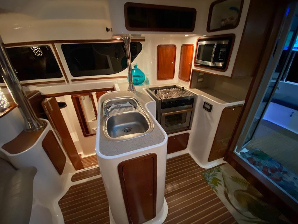 2013 Africat Marine AfriCat PowerCat Sportfisher kitchen interior with sink, stove, and microwave.