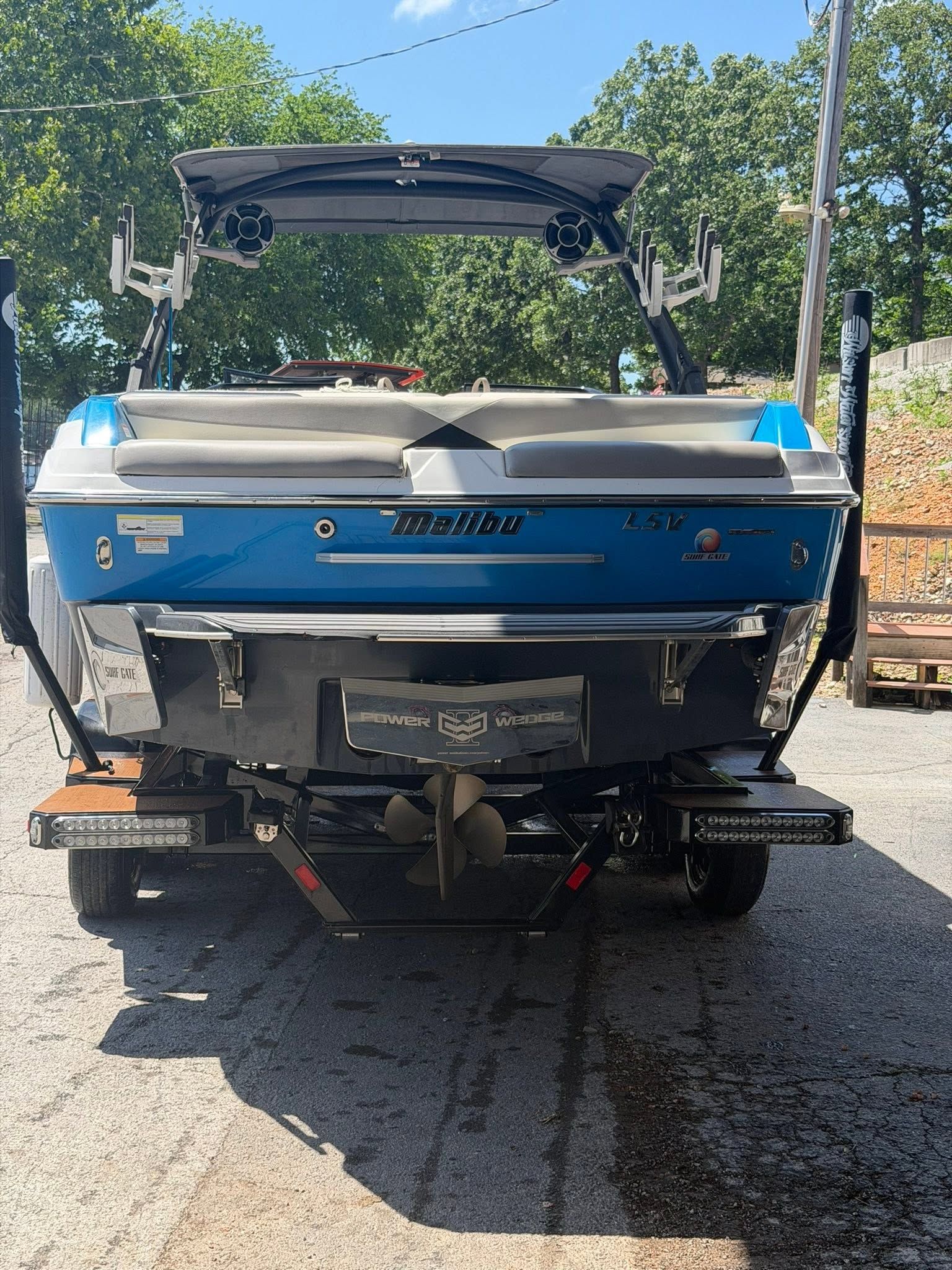 A blue 2015 Malibu Wakesetter 23 LSV is on a trailer in a parking area.