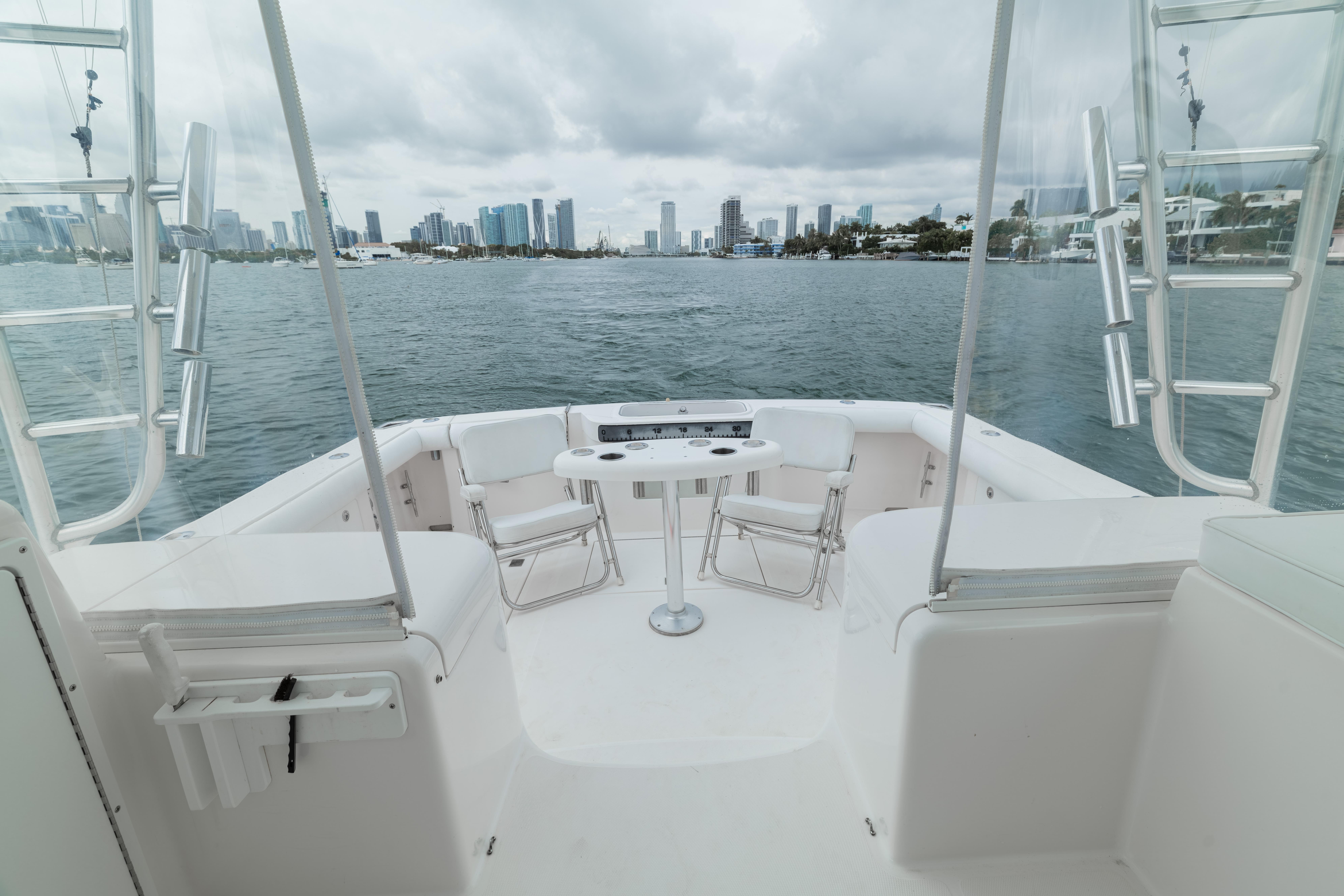 2006 Cabo 35 Express boat with city skyline view, featuring spacious deck and seating.