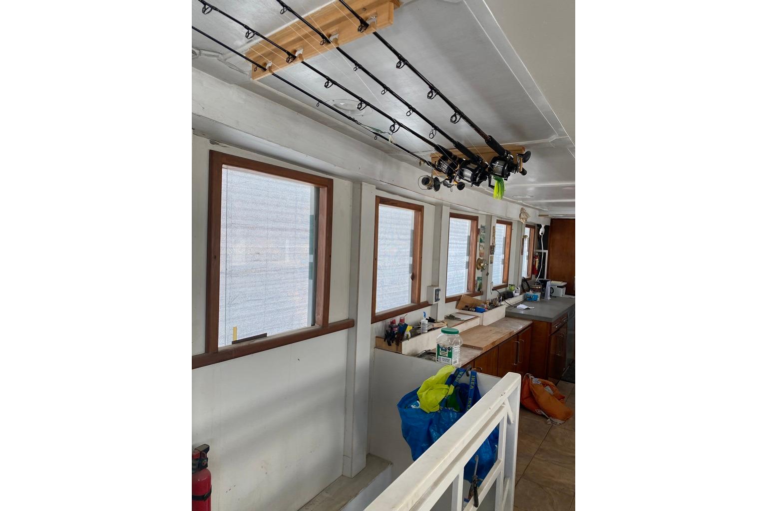 Interior of 1979 Shrimper Conversion Trawler with fishing rods and kitchen area.