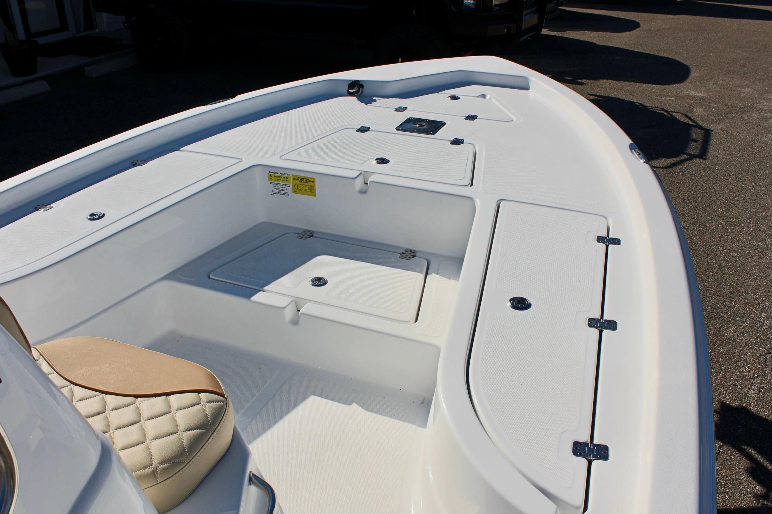 2025 NauticStar 214 Shallow Bay boat interior with storage compartments and seating.