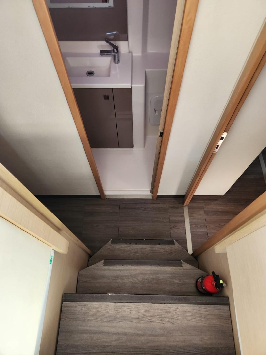 Interior of 2017 Fountaine Pajot Lucia 40 catamaran, featuring stairs and compact bathroom.