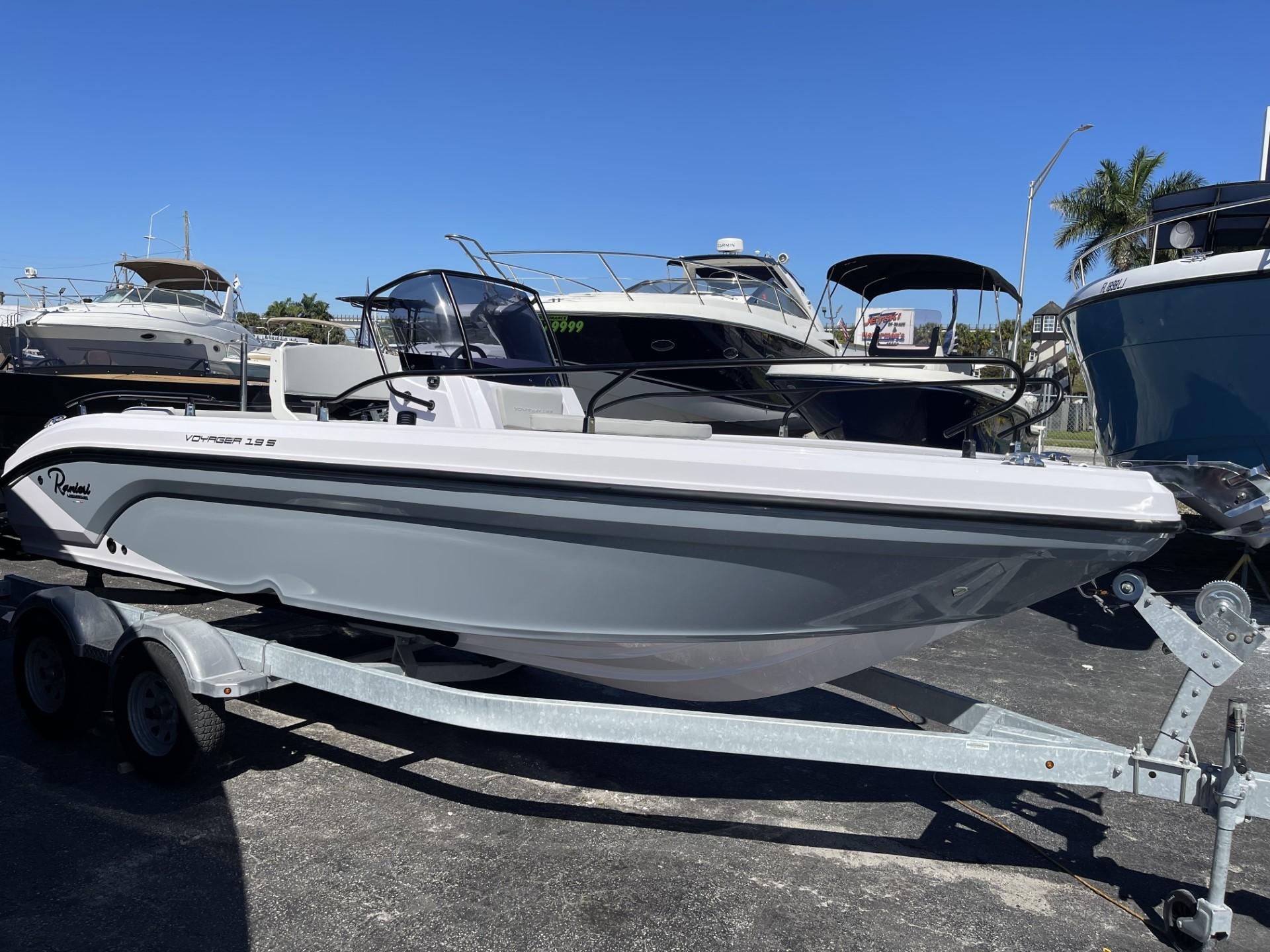 2024 Ranieri Voyager 19S boat on trailer, parked in marina under clear blue sky.