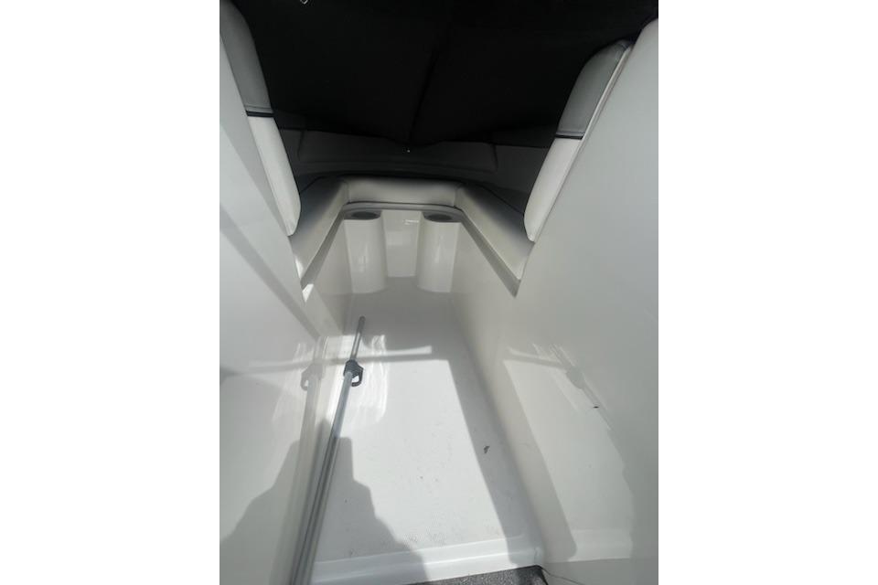 Interior view of a 2013 Bayliner 190 Bowrider boat, showcasing seating and storage area.