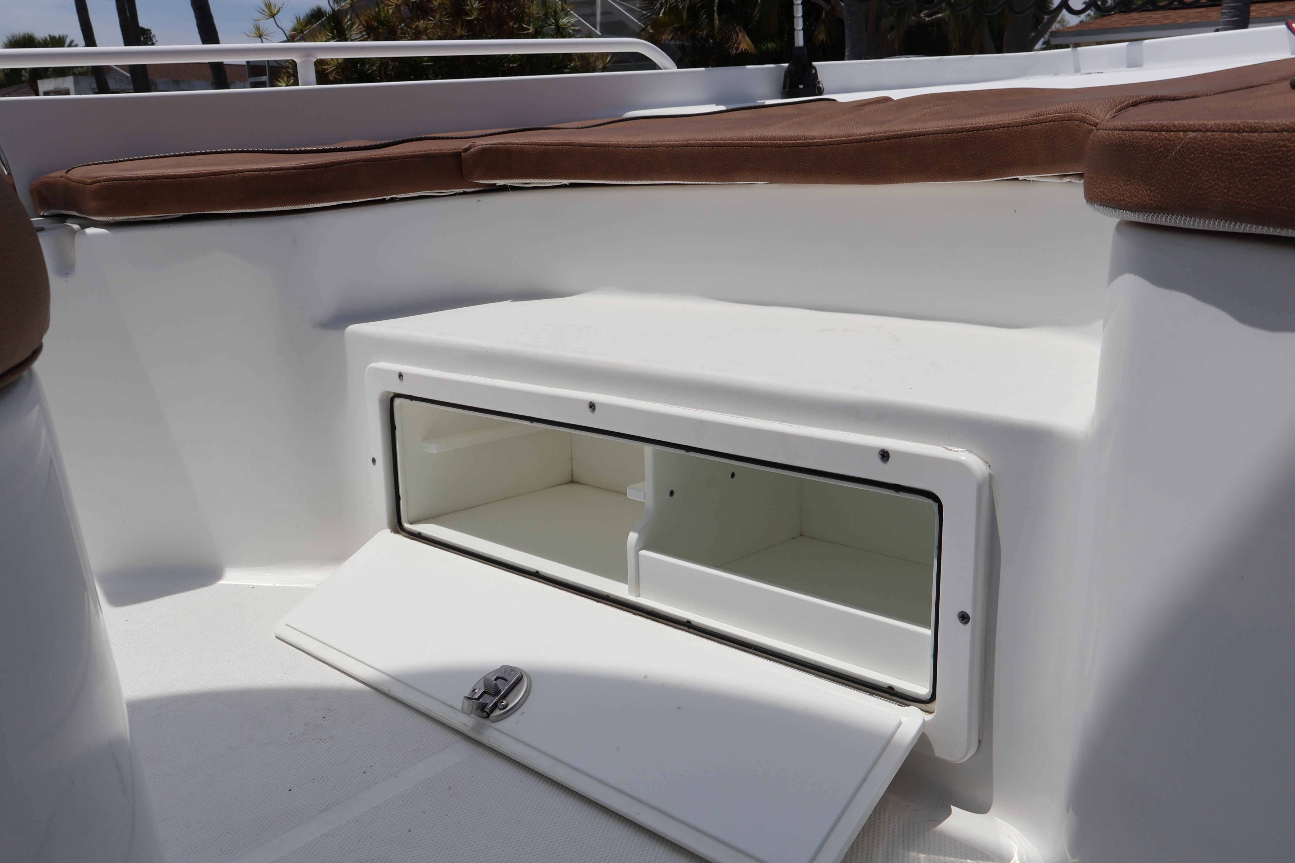 2022 Sea Hunt BX 25 FS boat storage compartment with open hatch and cushioned seating.