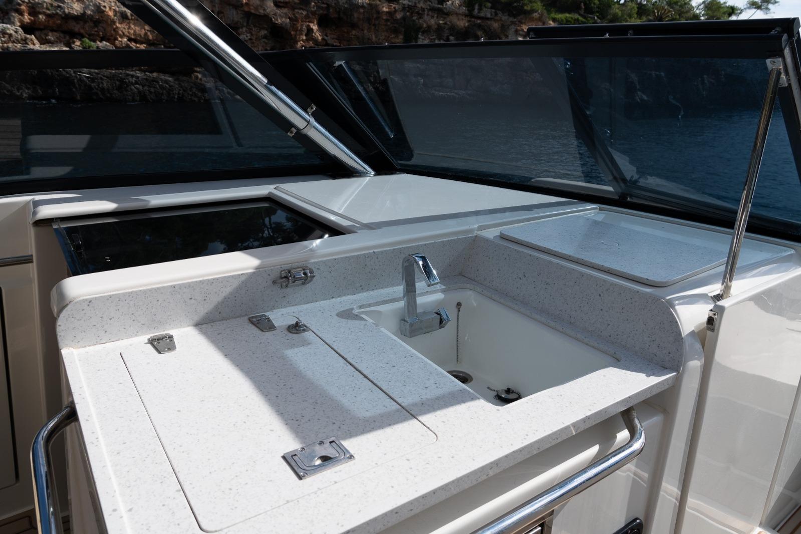 Aquila 32 yacht's sleek kitchen area with modern sink and countertop, 2023 model.