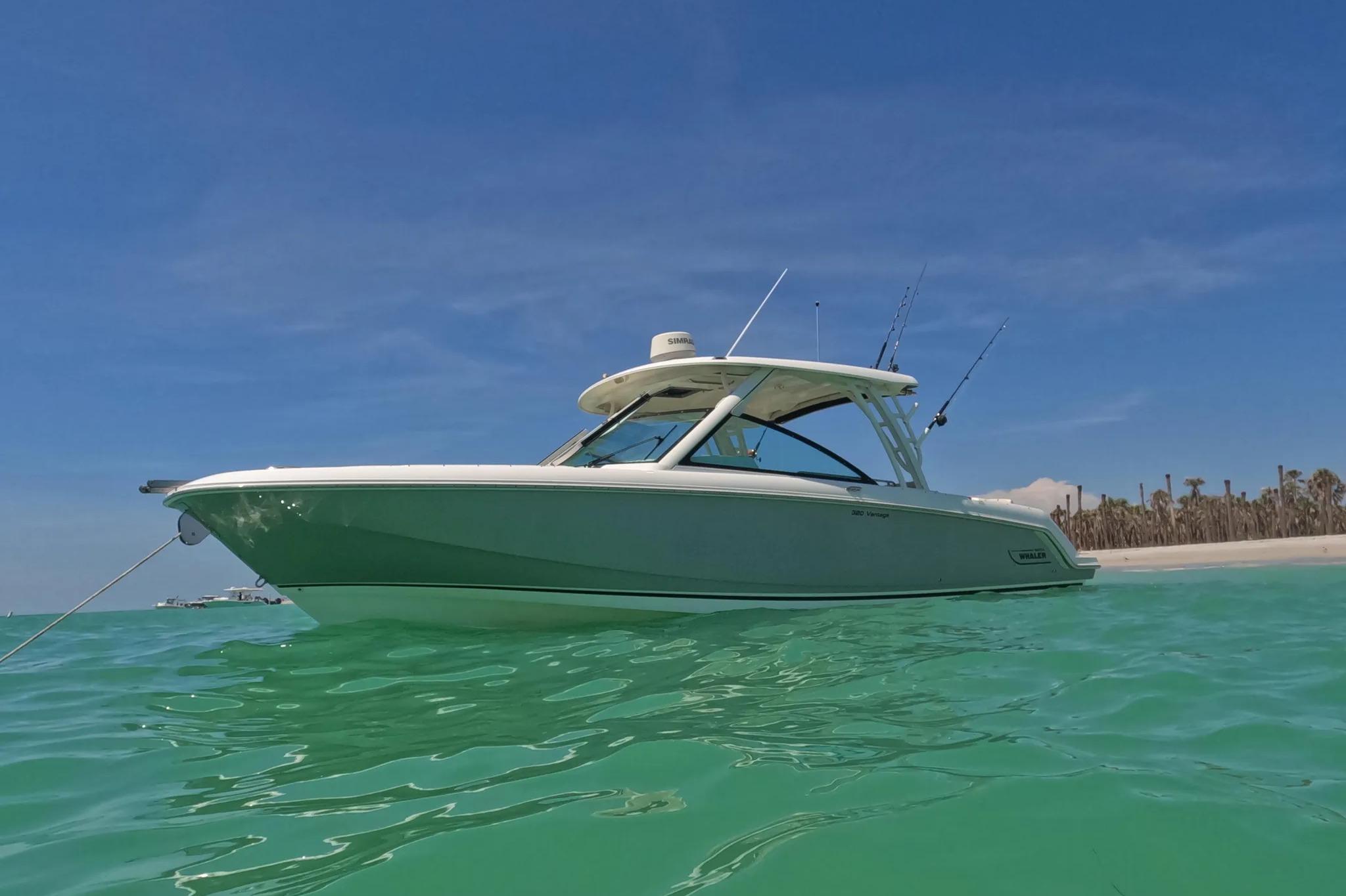 2017 Boston Whaler 320 Vantage boat on turquoise water under clear blue sky.
