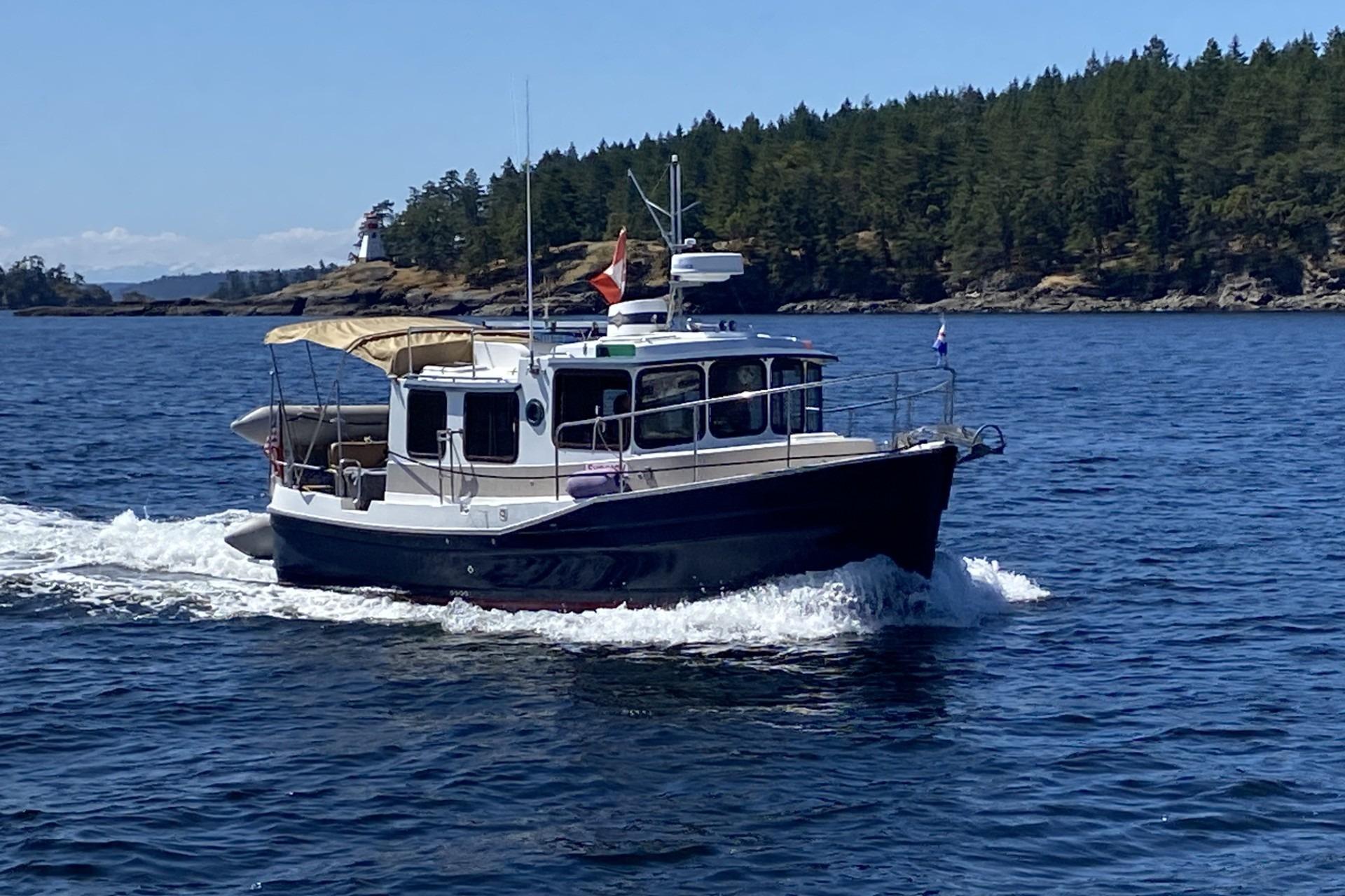 2008 Ranger 25 cruising past a forested shoreline.
