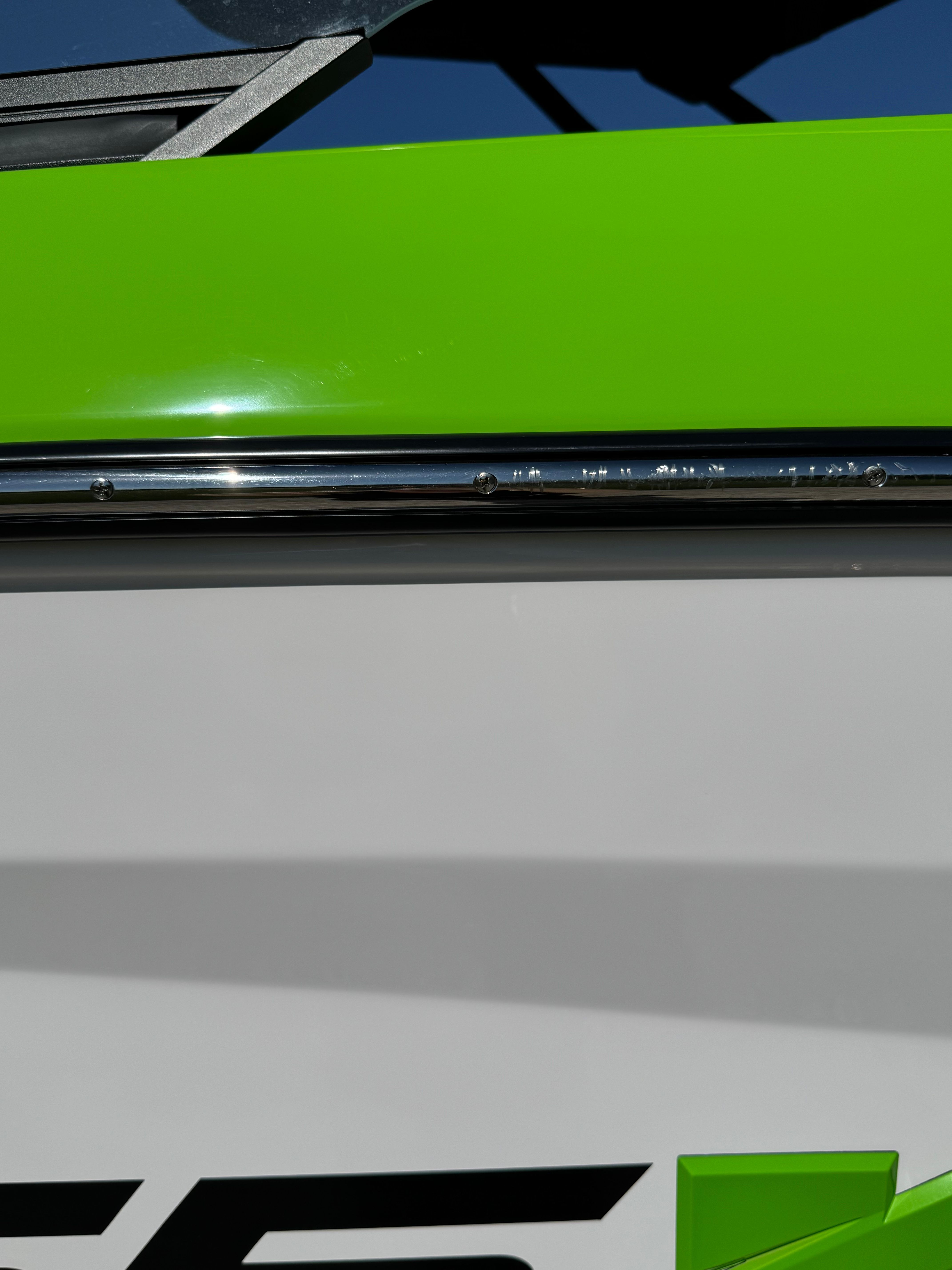 Close-up of a green and white boat with chrome details.