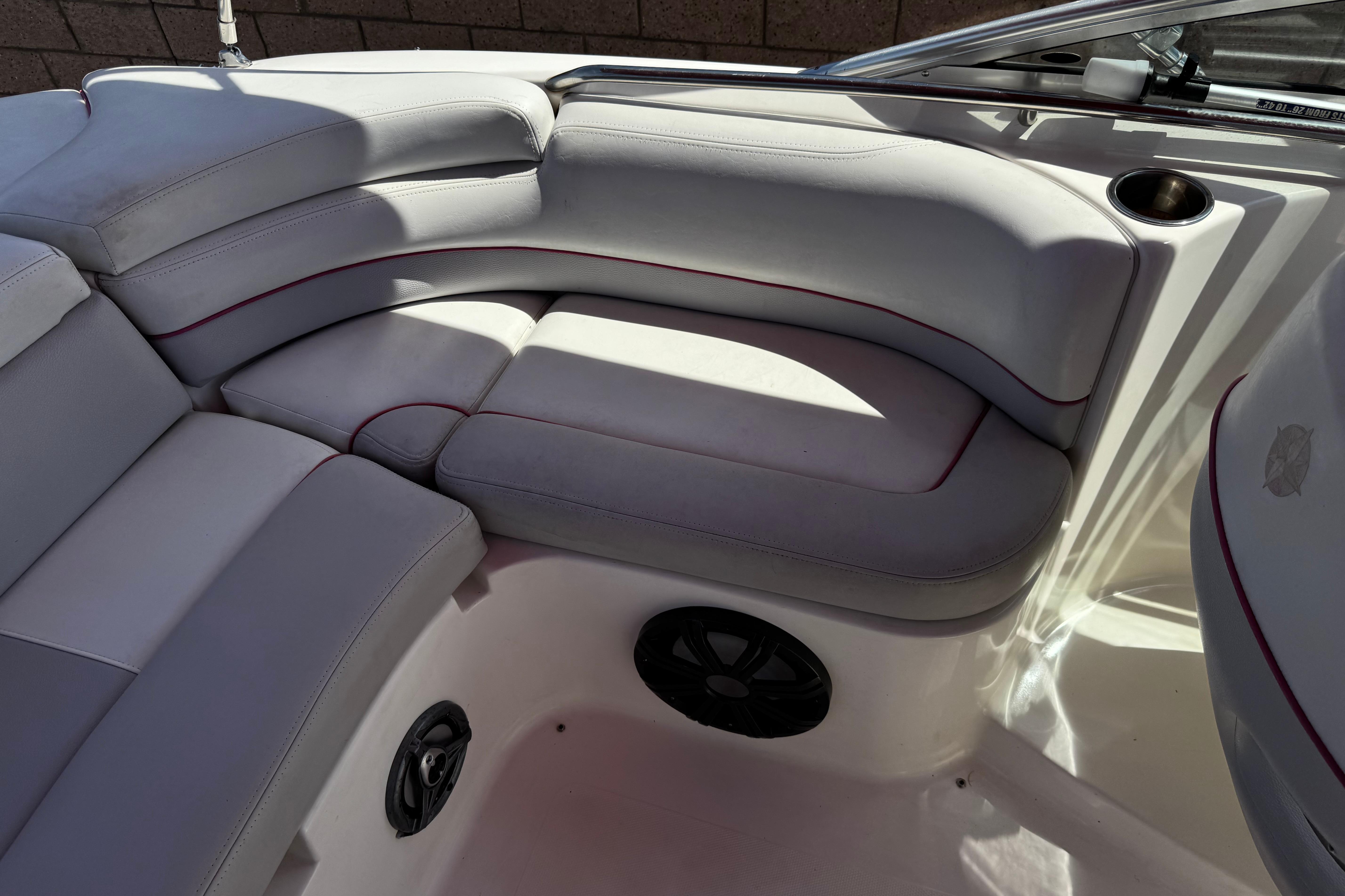 Interior seating of a 2010 Bryant 255 boat with gray upholstery and cup holder.