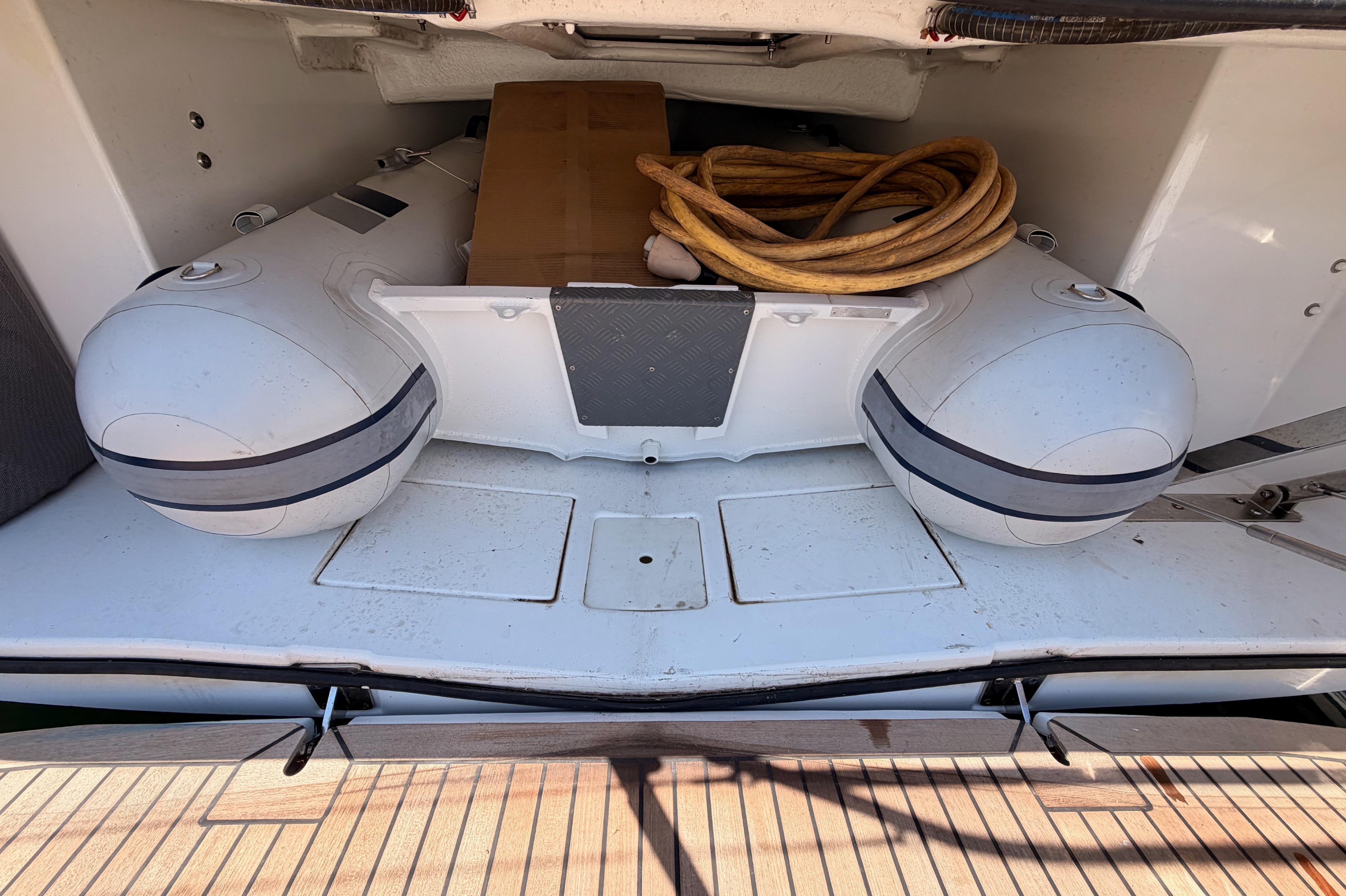 Storage compartment of 2022 Beneteau Oceanis Yacht 54 with inflatable dinghy and coiled rope.