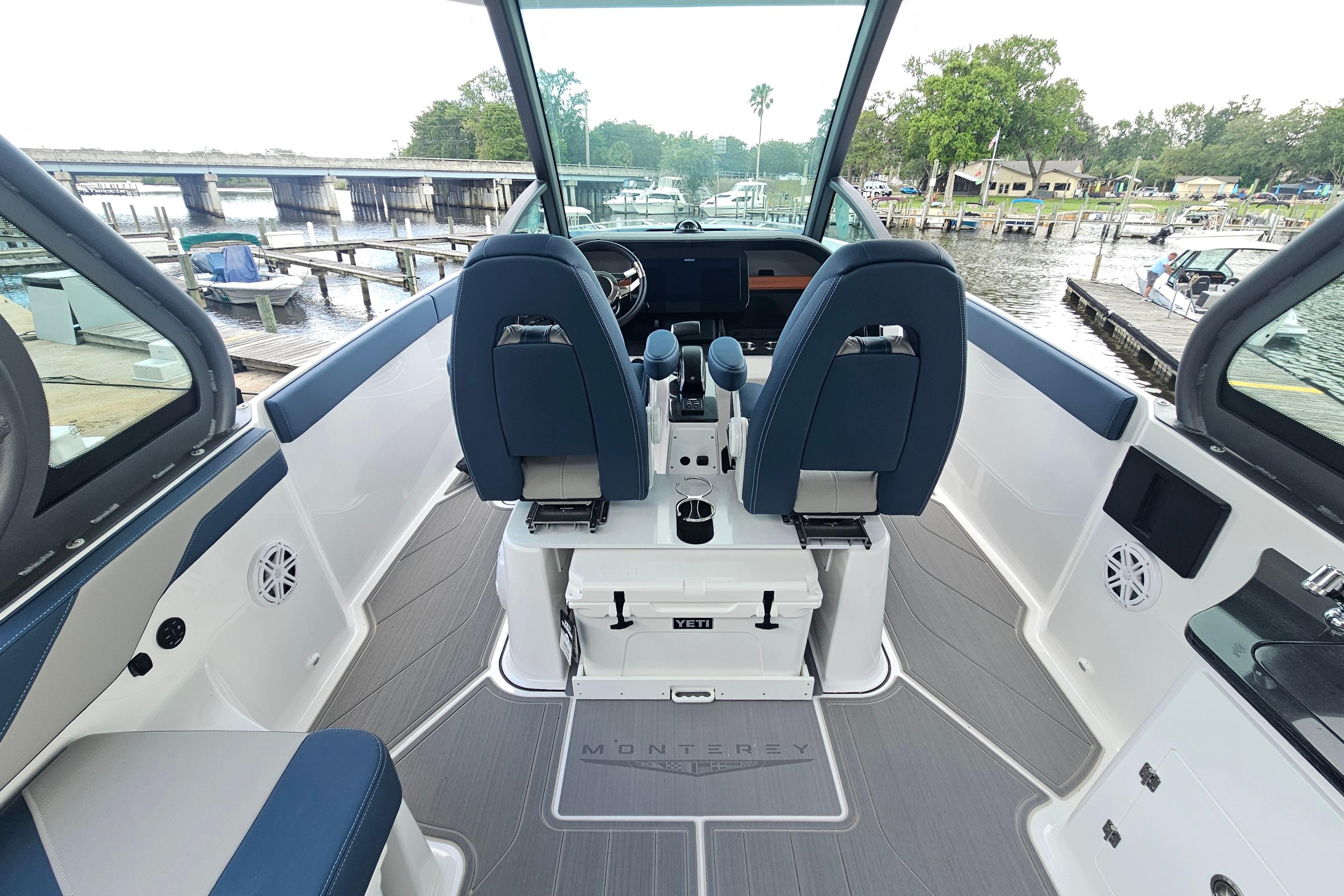Interior view of a 2026 Monterey Elite 27 OB boat, featuring sleek seating and modern controls.