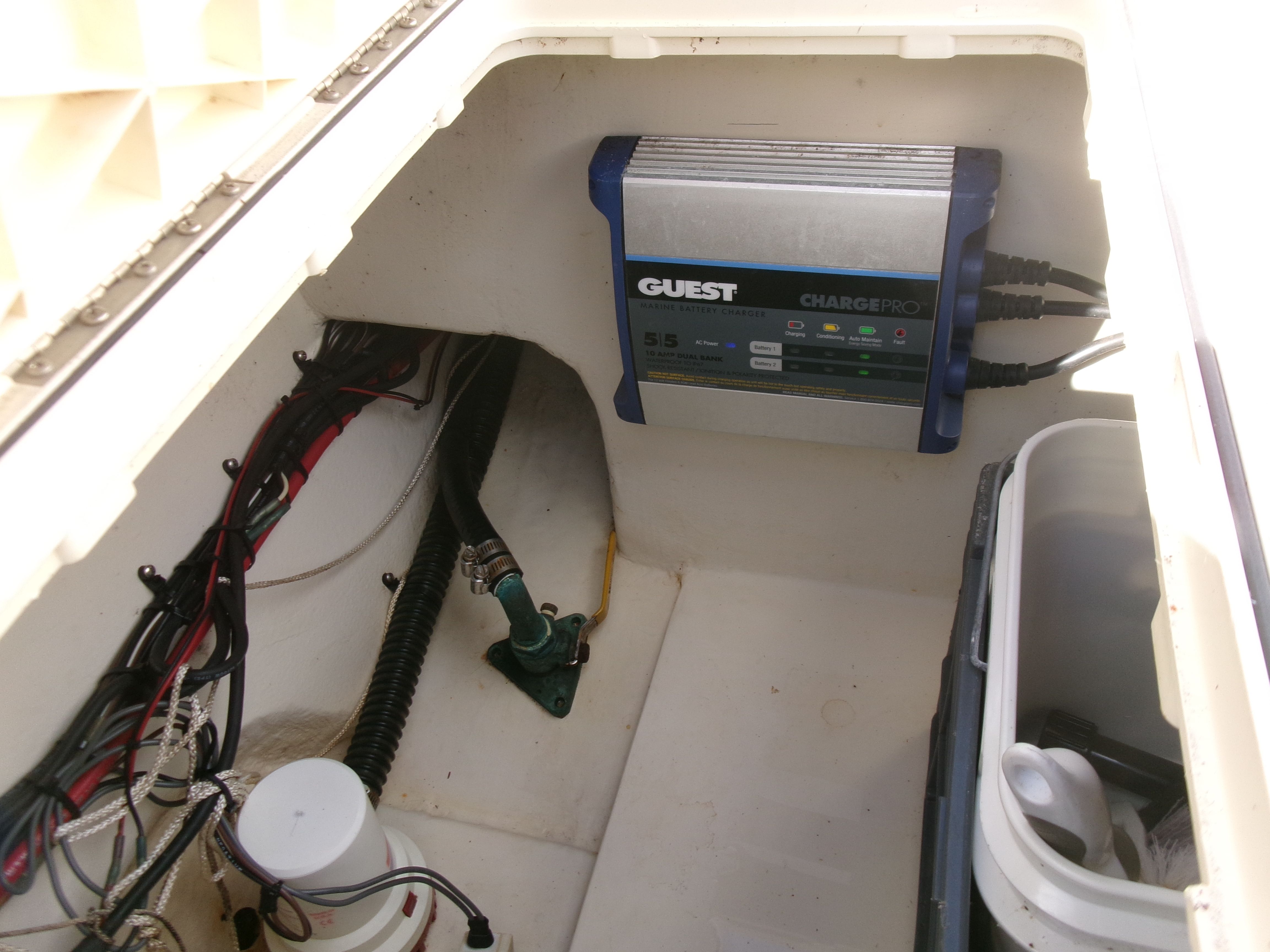 A view inside the technical compartment of a 2007 Parker 2520 XL Sport Cabin boat with wiring and charger.