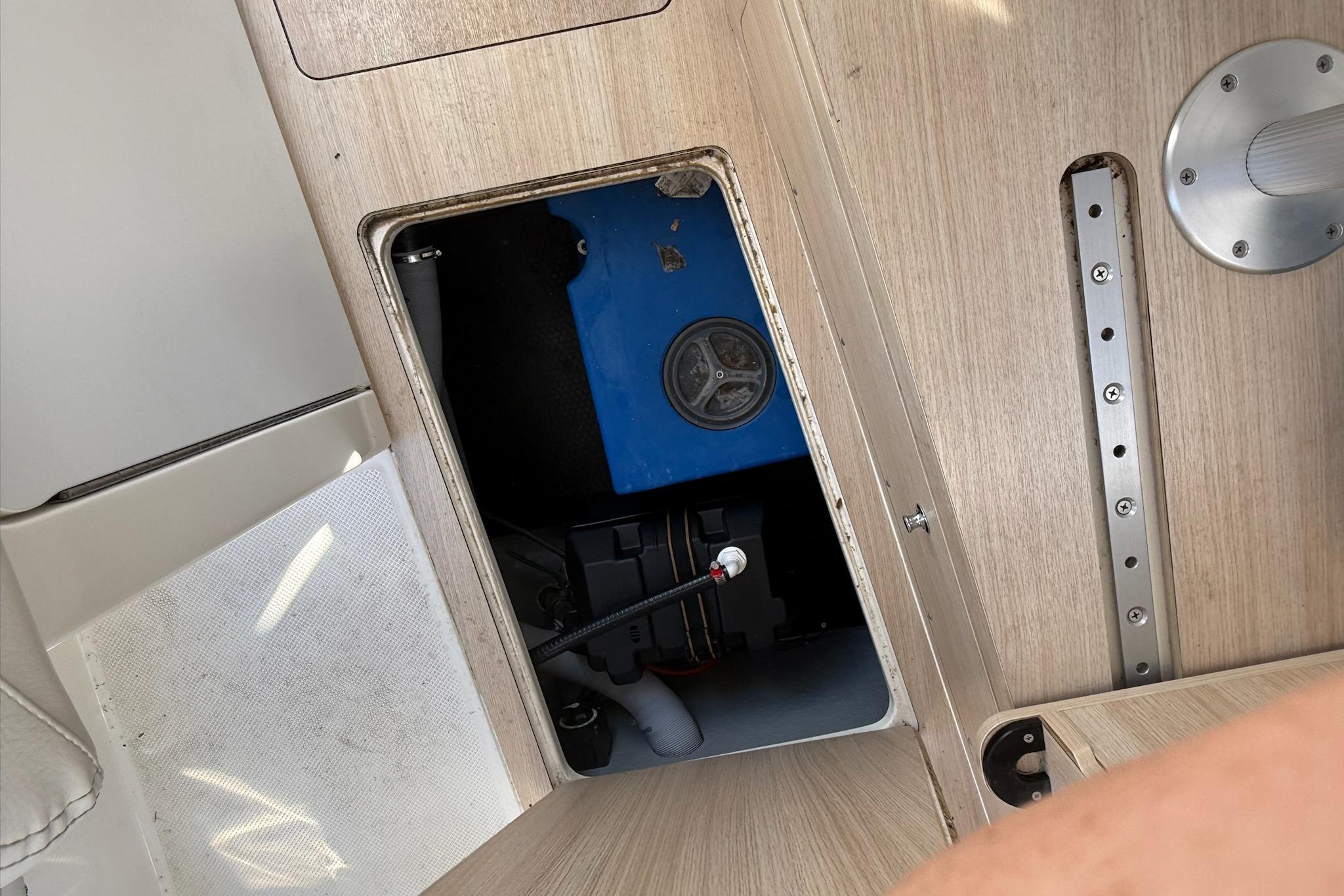 2024 Bayliner Trophy T25 Pilothouse interior compartment with blue equipment and wooden finish.