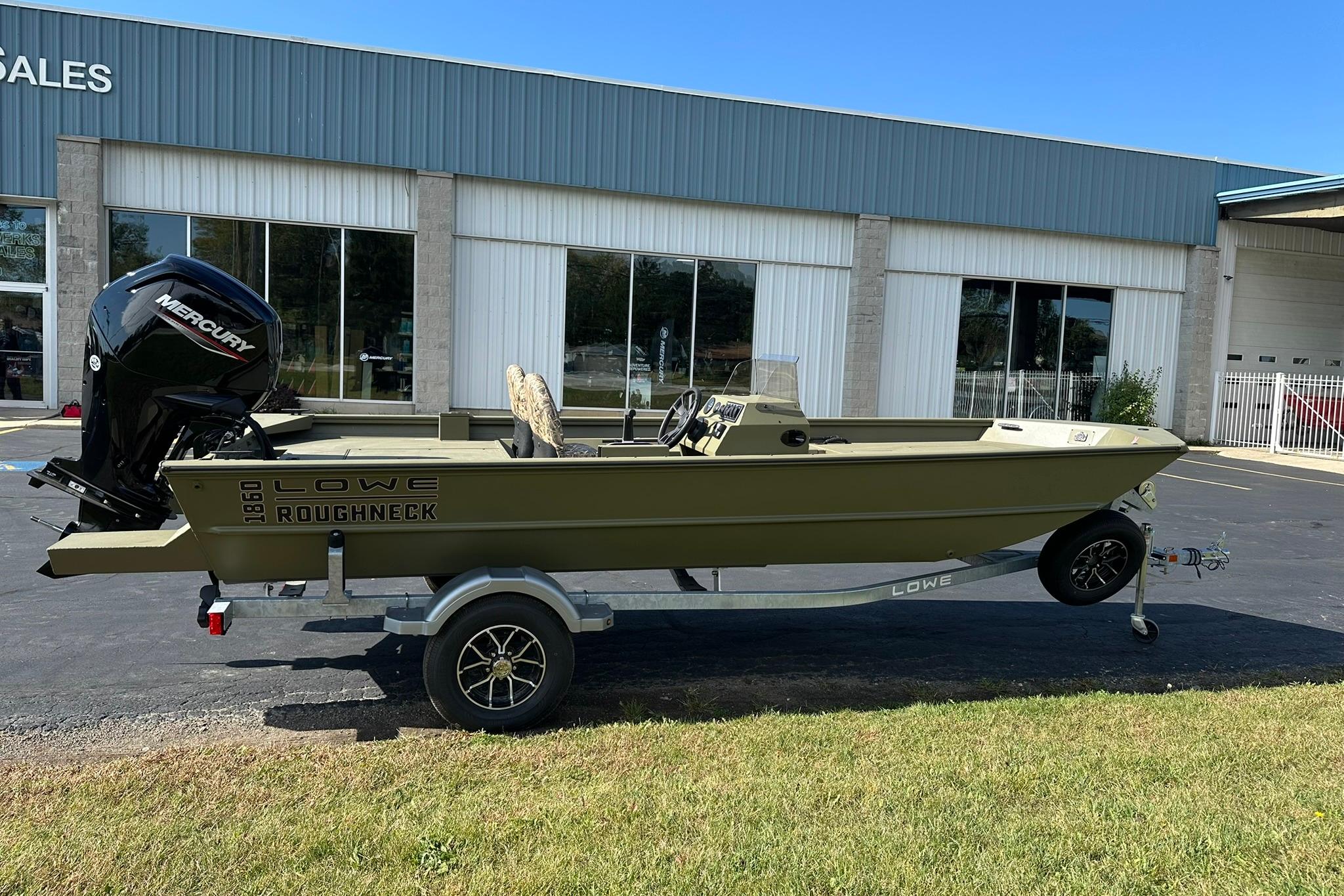 2026 Lowe Roughneck 1860SC boat on trailer, parked outside a sales building.