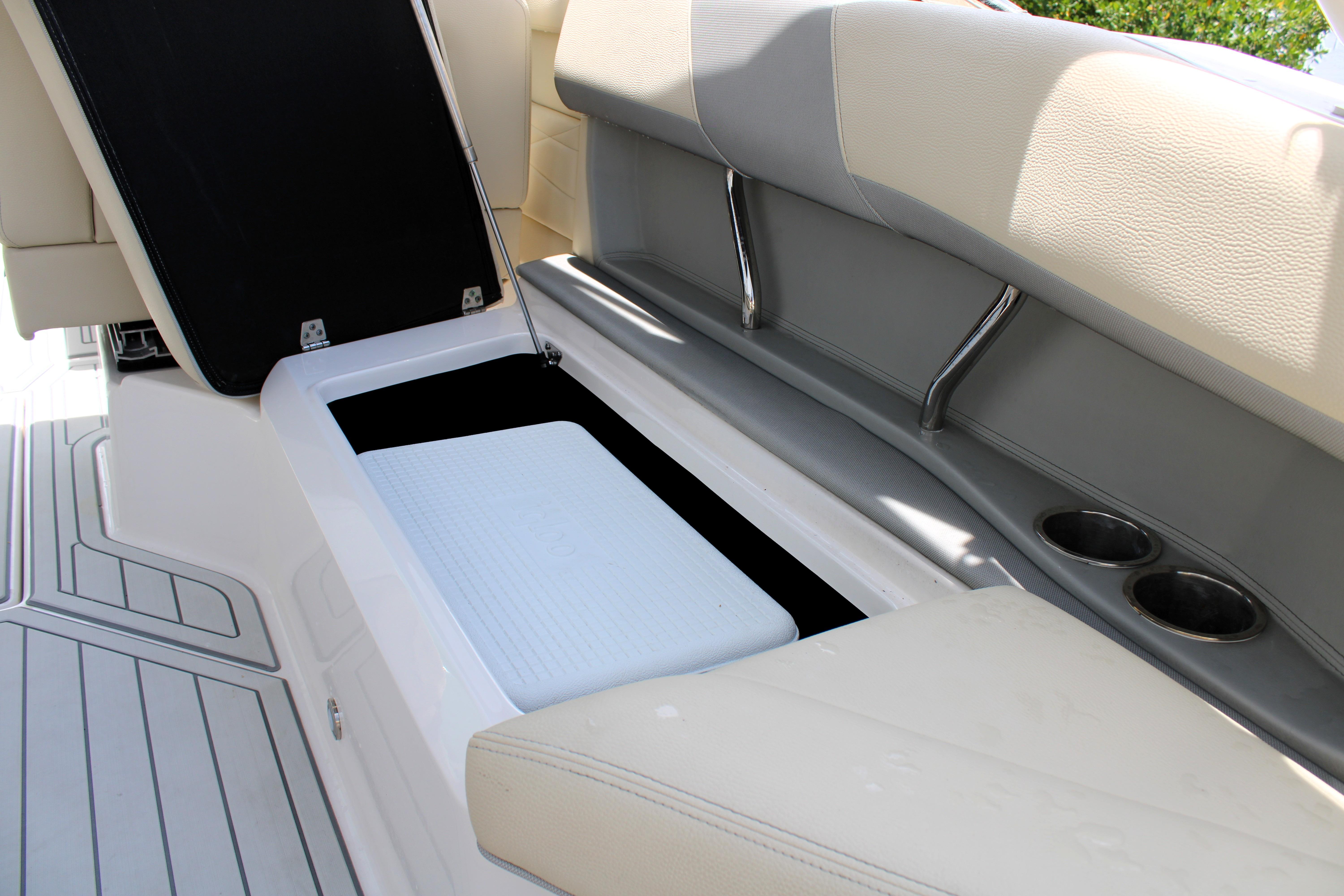 2021 Regal 26 OBX boat interior storage compartment with open lid and cup holders.