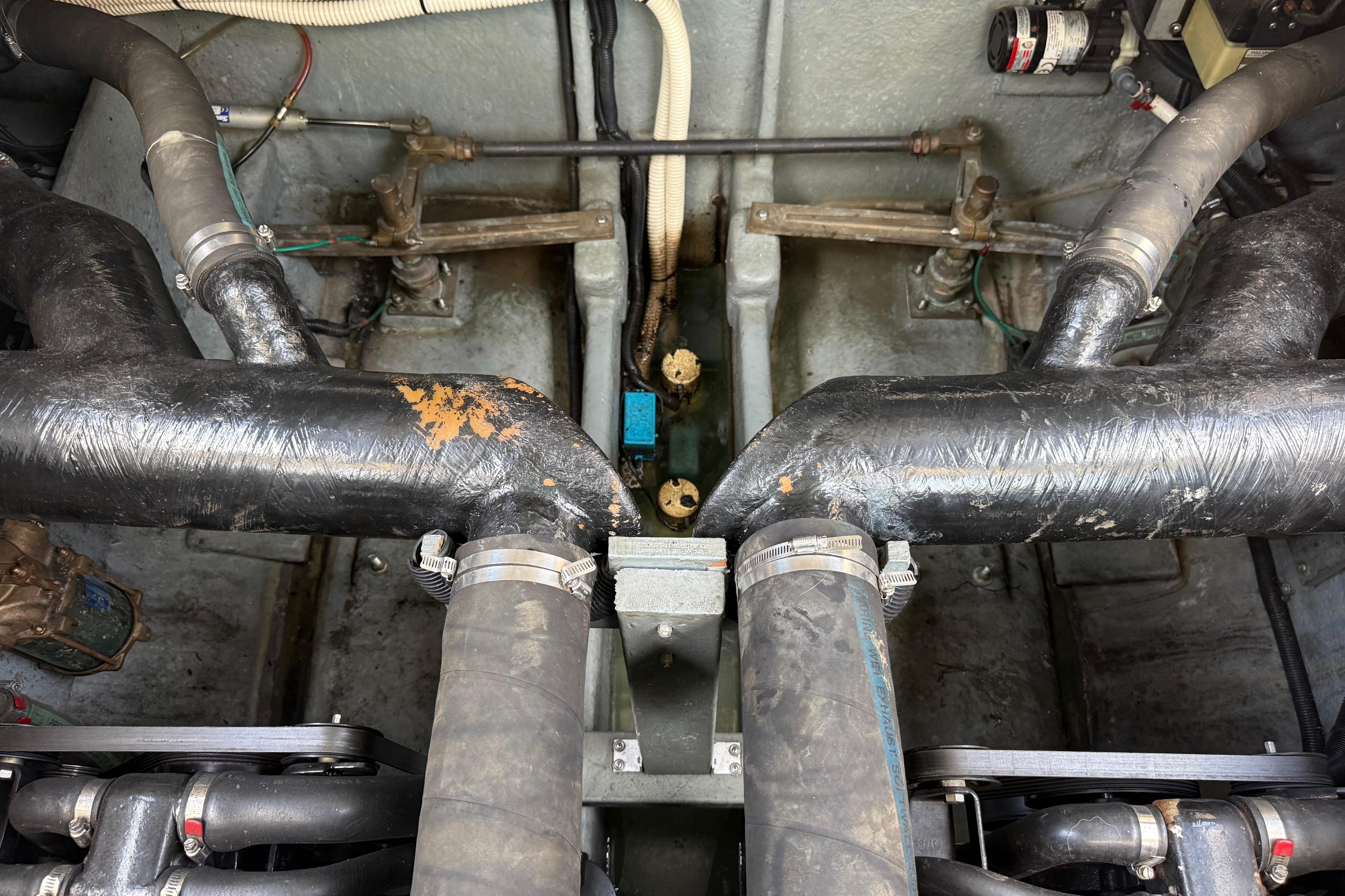 Engine compartment of a 1999 Sea Ray Sundancer 310 with visible hoses and components.