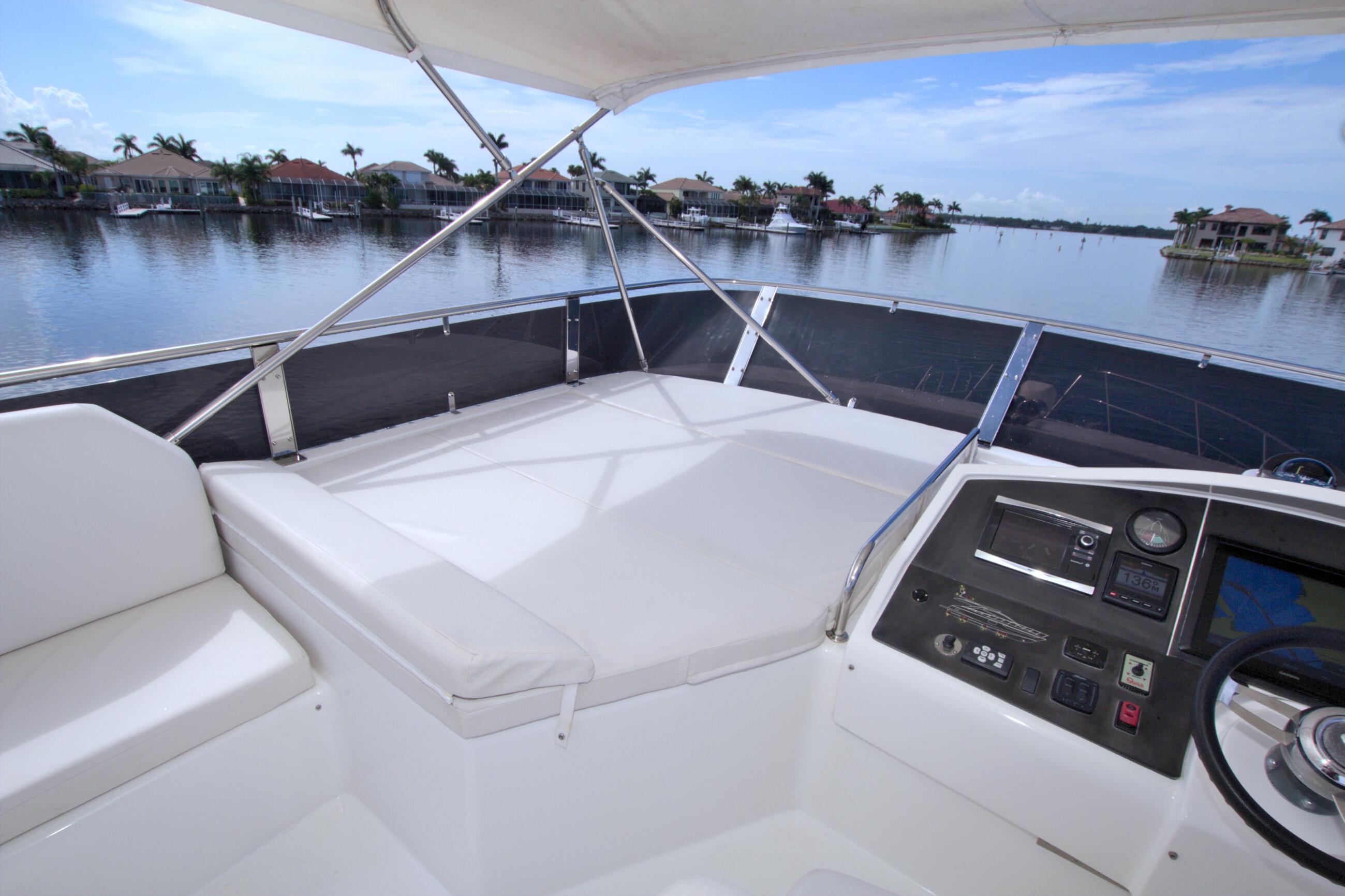 Helm of 2015 Dyna 60 yacht with waterfront view and modern controls.