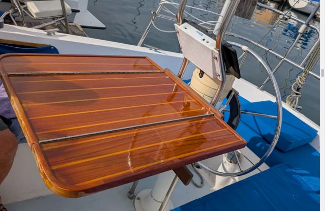 A 1982 Catalina sailboat with a glossy wooden table and a steering wheel in the cockpit.