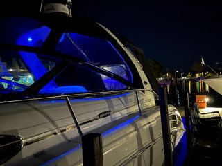 2005 Sea Ray Sundancer yacht at night with blue lighting.