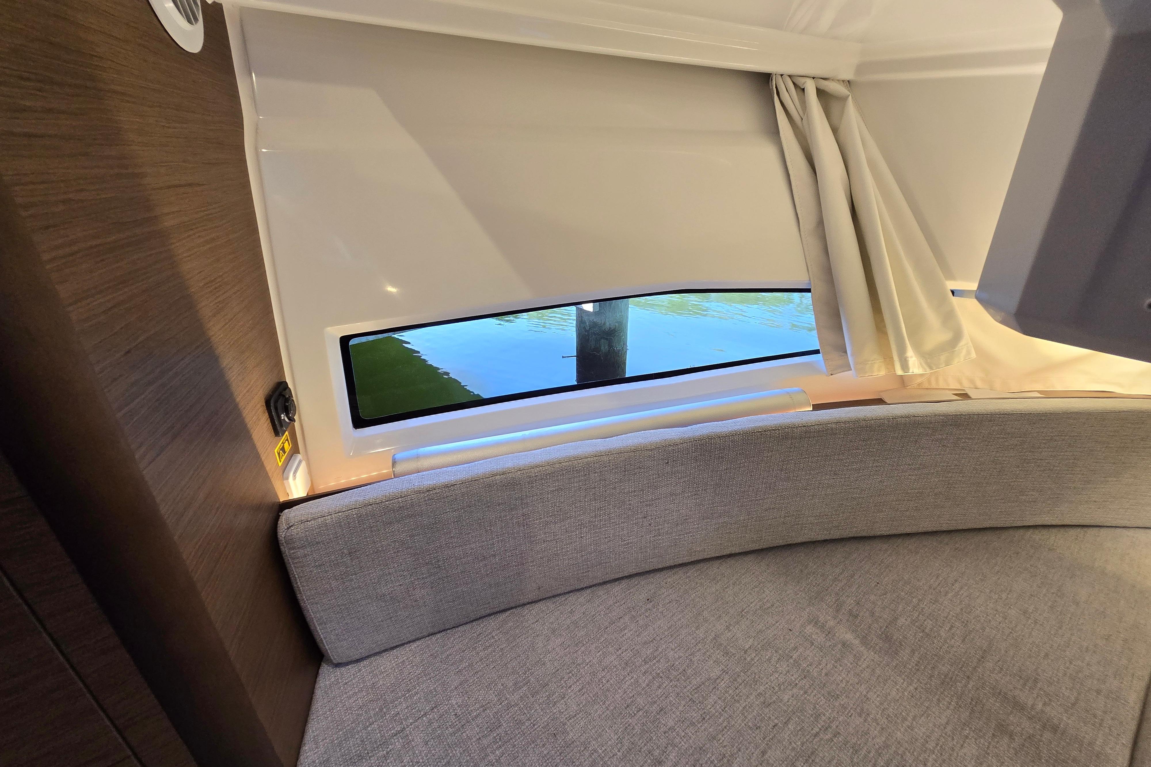 Interior of the Jeanneau NC Sport 895 with a window overlooking the water.