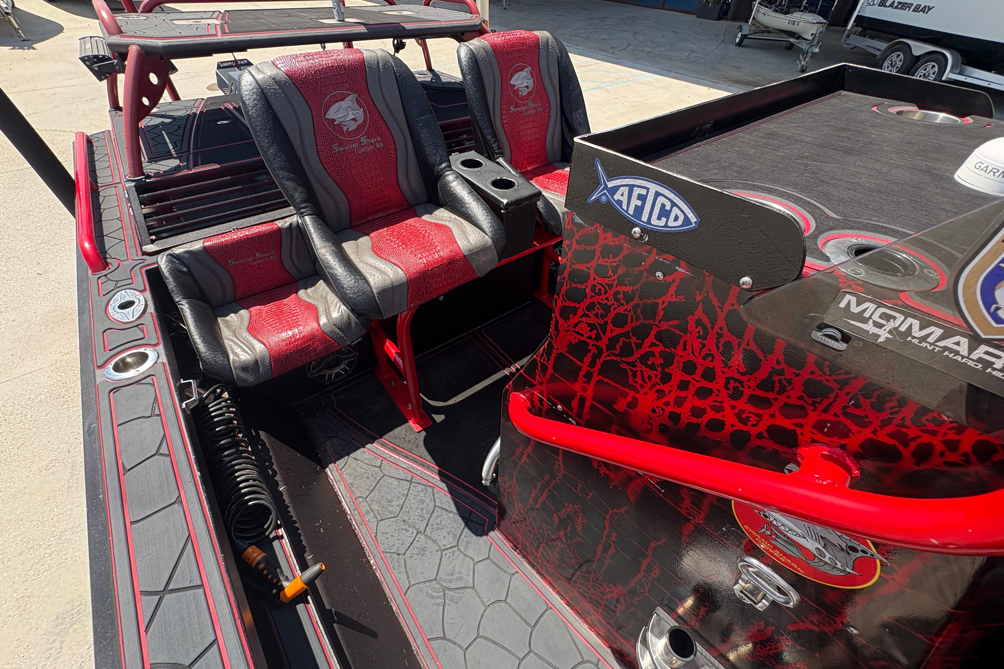 Custom 2018 Swamp Shark 24' boat interior with red and black seating and fishing gear.