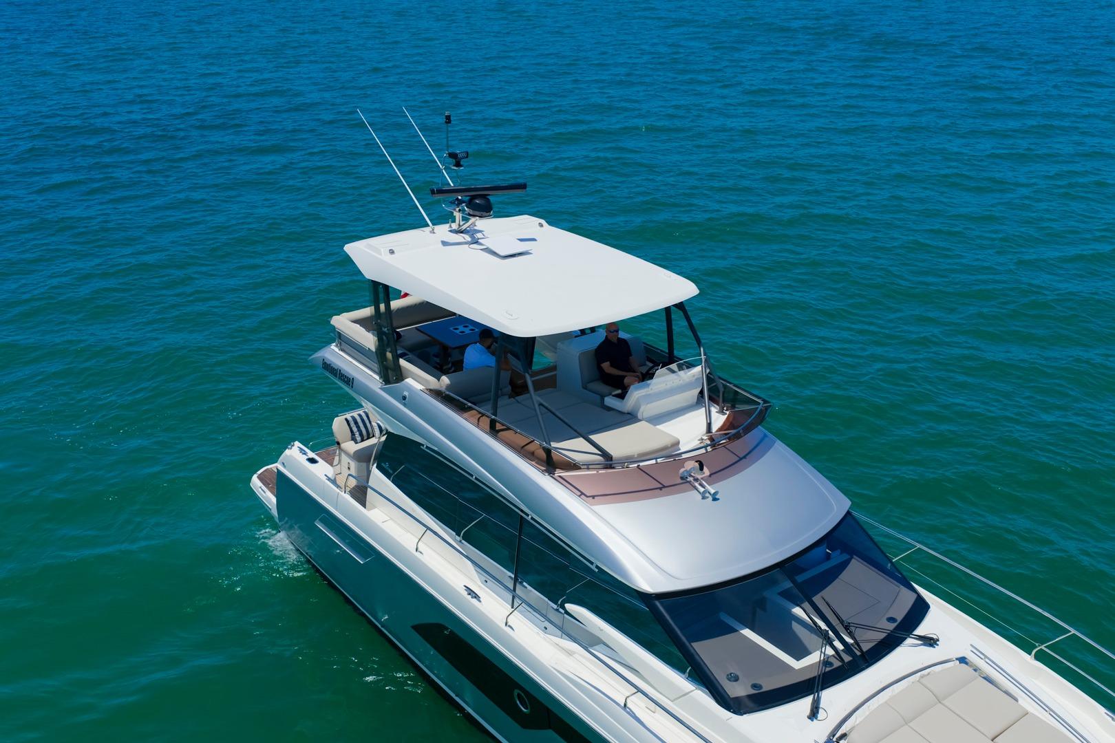 Luxury 2022 Prestige 520 yacht cruising on clear blue ocean waters.