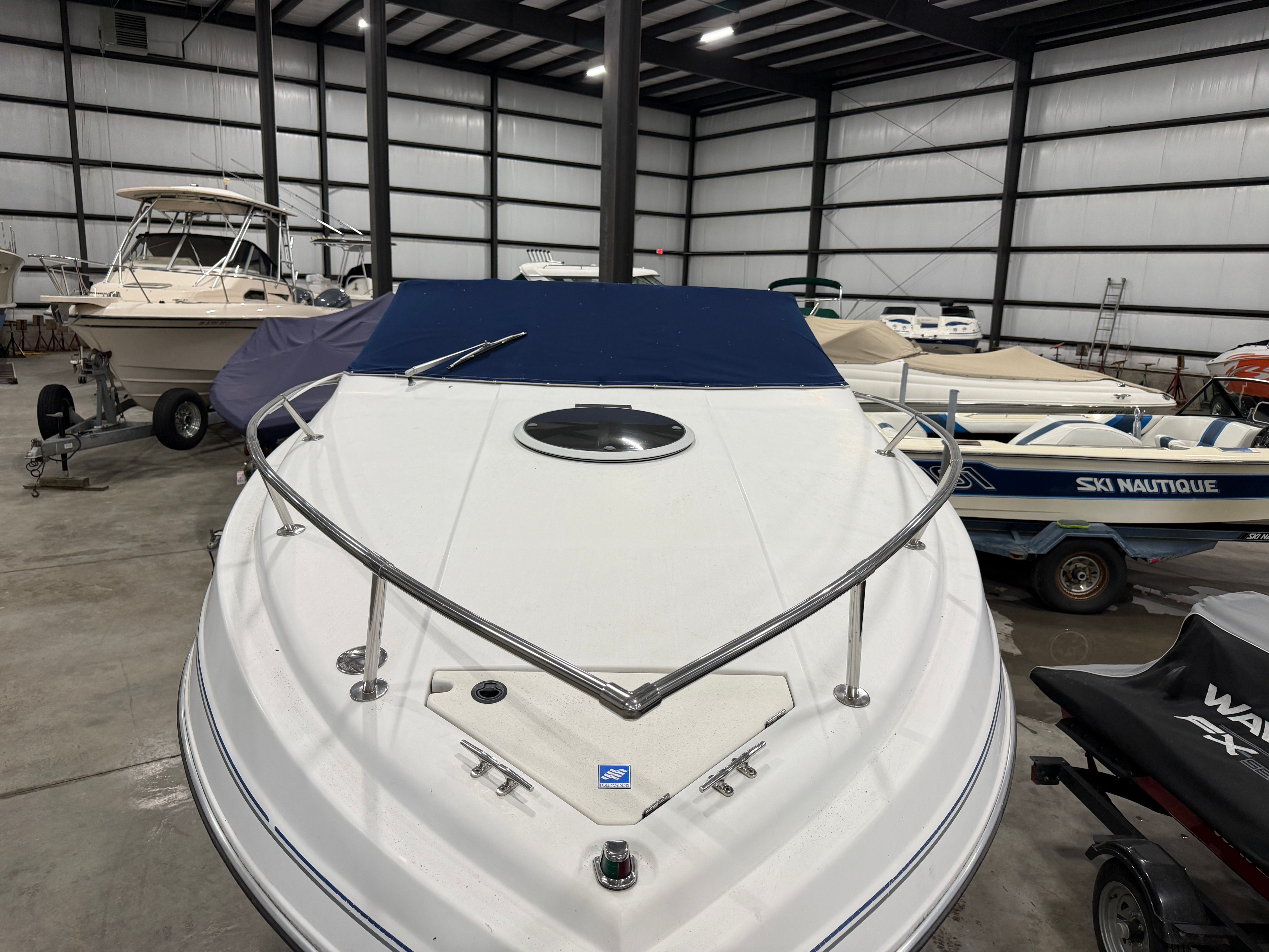 1992 Four Winns 225 Sundowner in a warehouse with other boats.