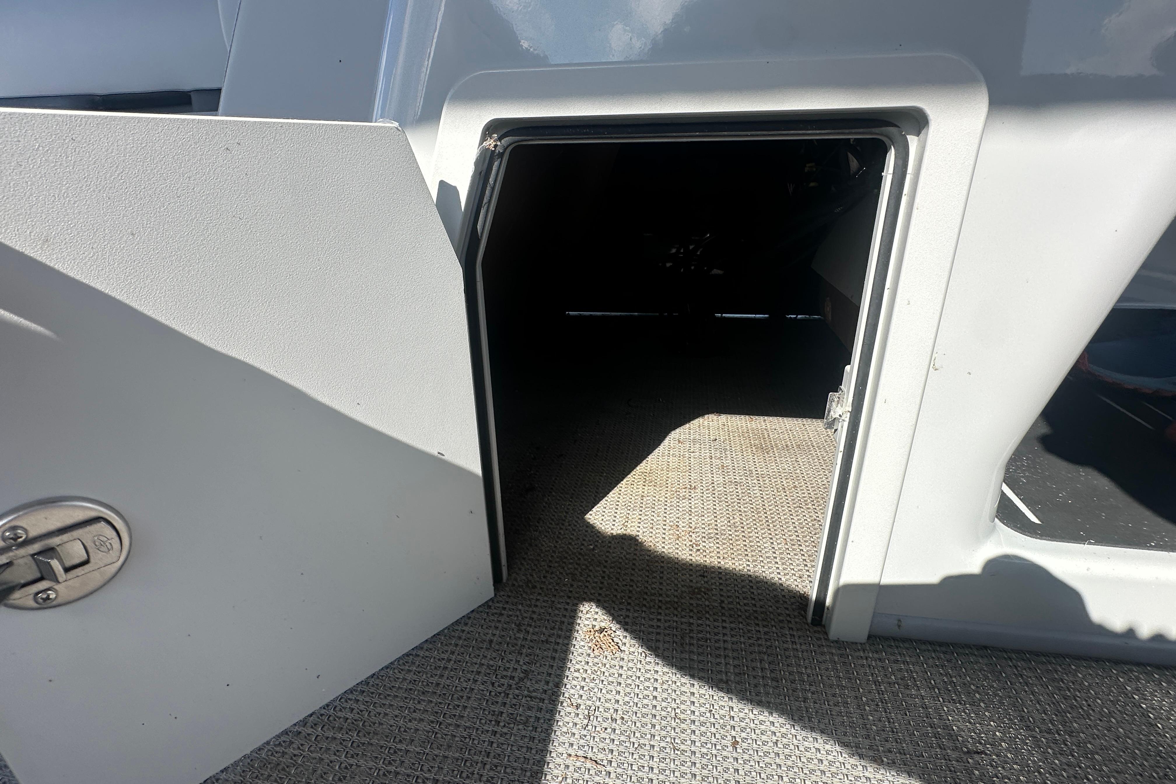 Open storage compartment on 2023 Bentley Pontoons Legacy 243 Swingback boat.