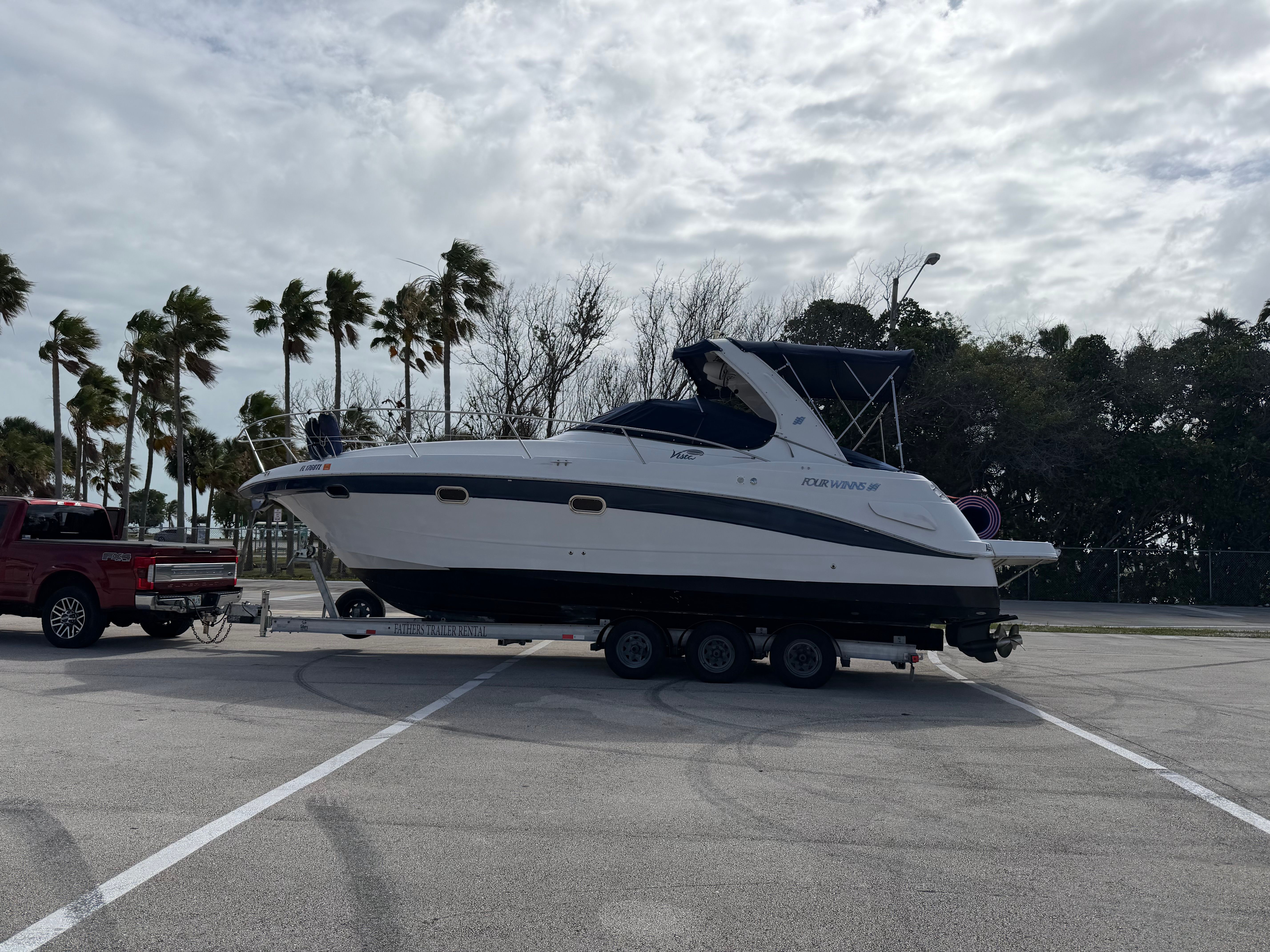 2006 Four Winns 328 Vista boat on trailer, cloudy sky.