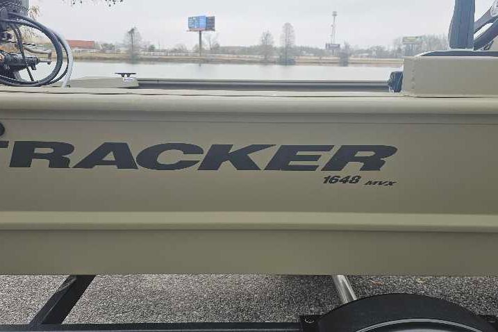 2026 Tracker Grizzly 1648 SC boat side view near a lake.