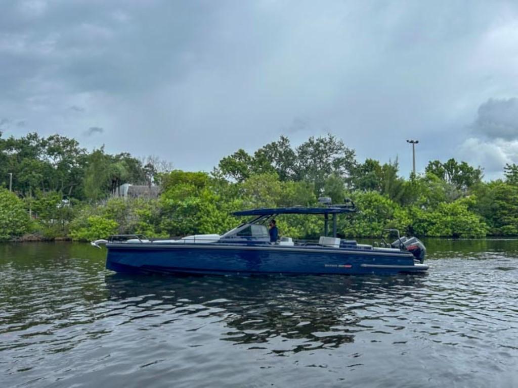 2024 BRABUS Shadow 1000 ST boat on a calm river with lush greenery.