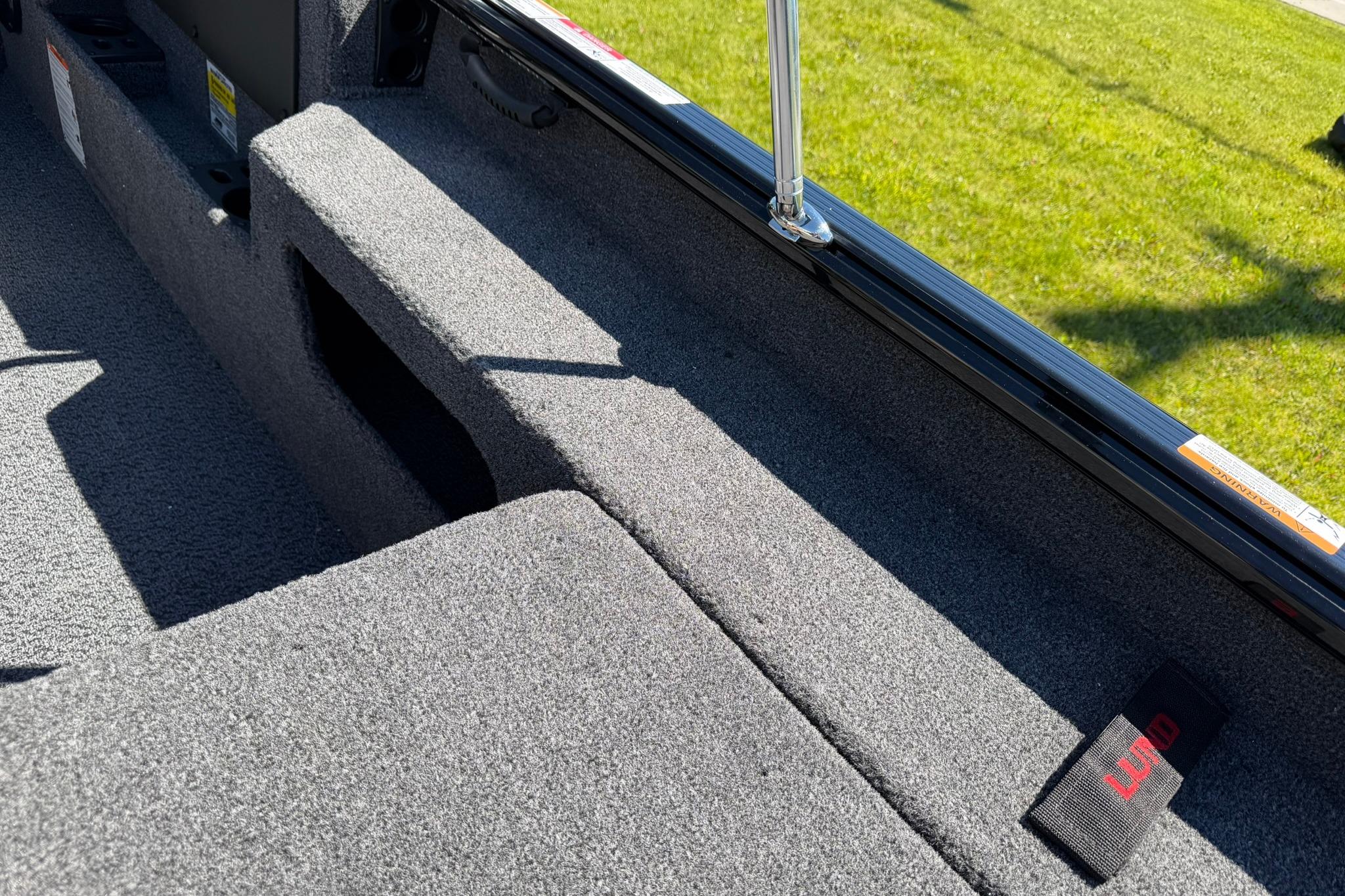 Interior view of 2027 Lund 1775 Impact XS Sport boat with carpeted flooring.