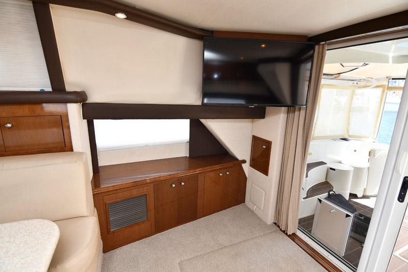 Interior of 2008 Carver 43 Super Sport yacht with TV and wooden cabinetry.