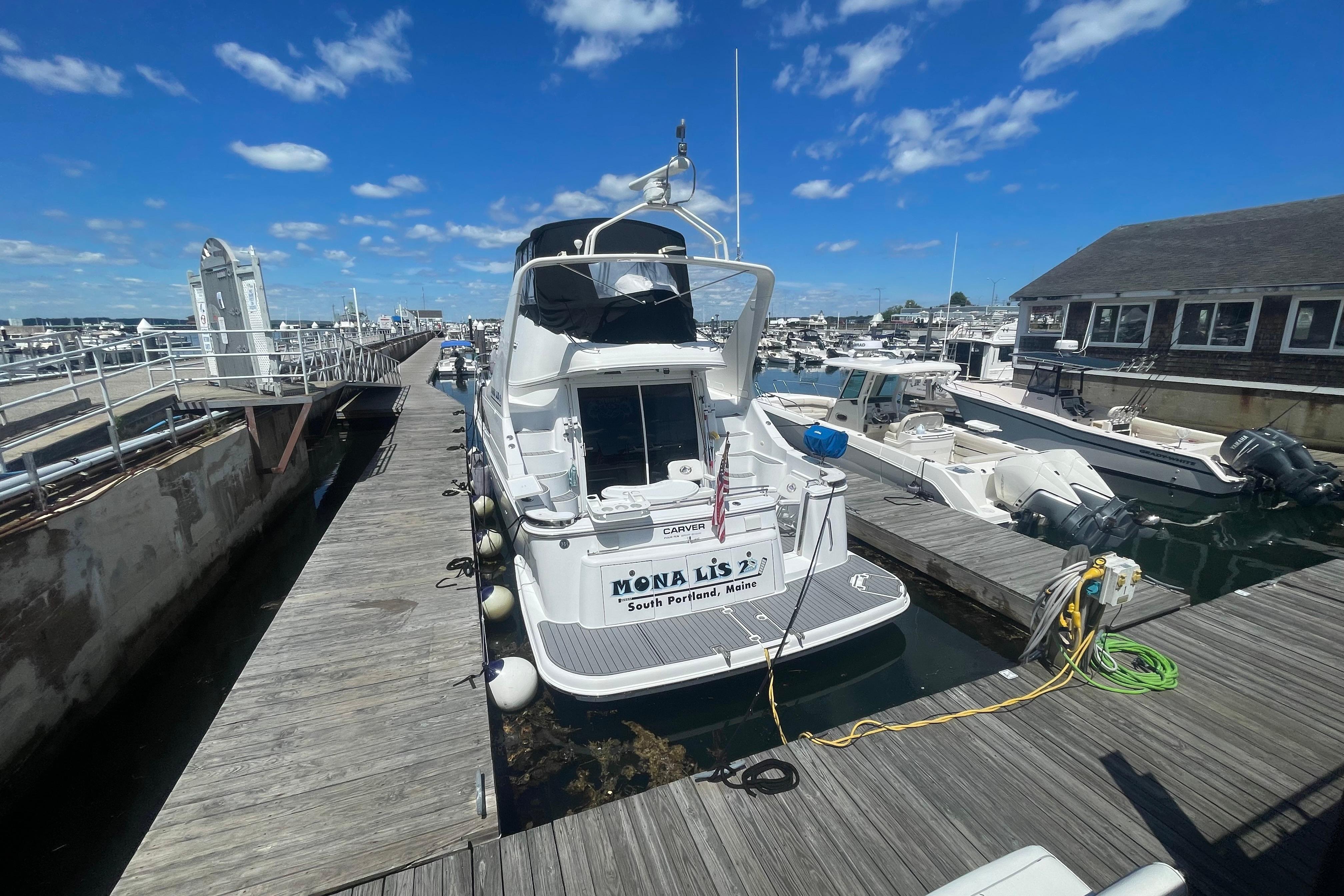 2002 Carver 410 Sport Sedan docked at marina under blue sky.