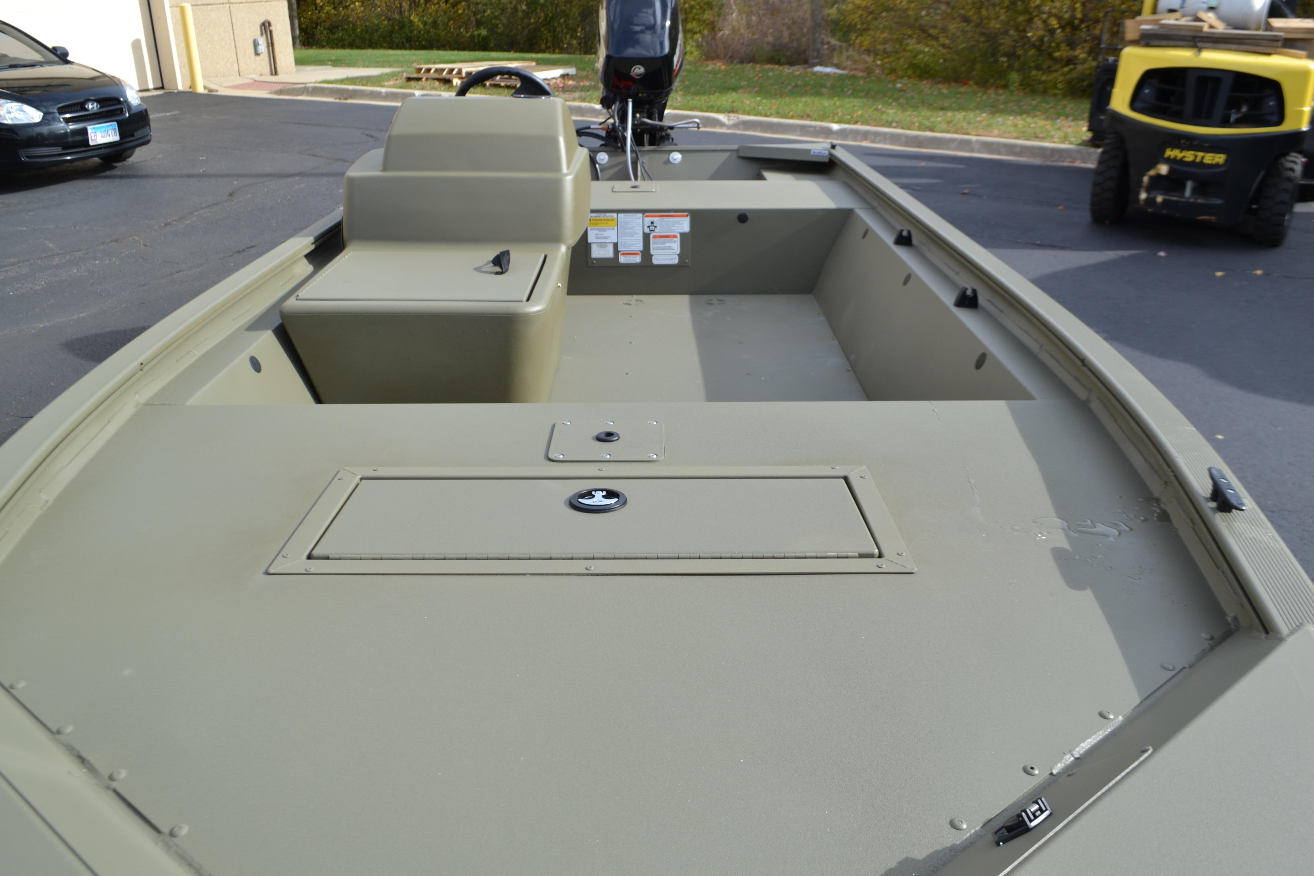 2026 Tracker Grizzly 1648 SC boat, olive green, parked outdoors.